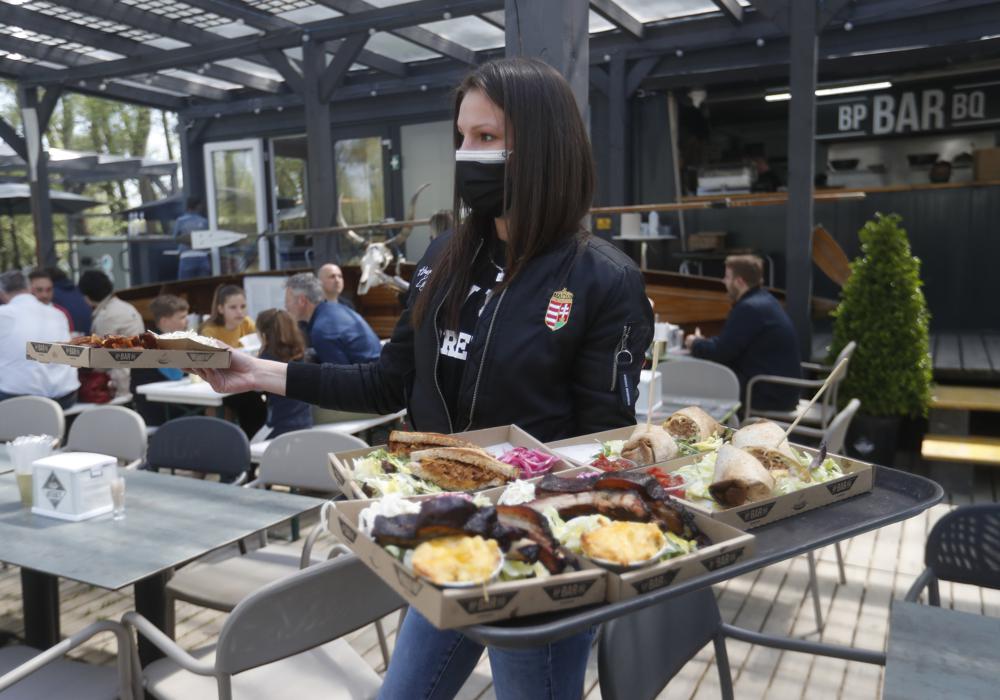 A waitress serves food in the outside terrace of a bar in Budapest, Hungary