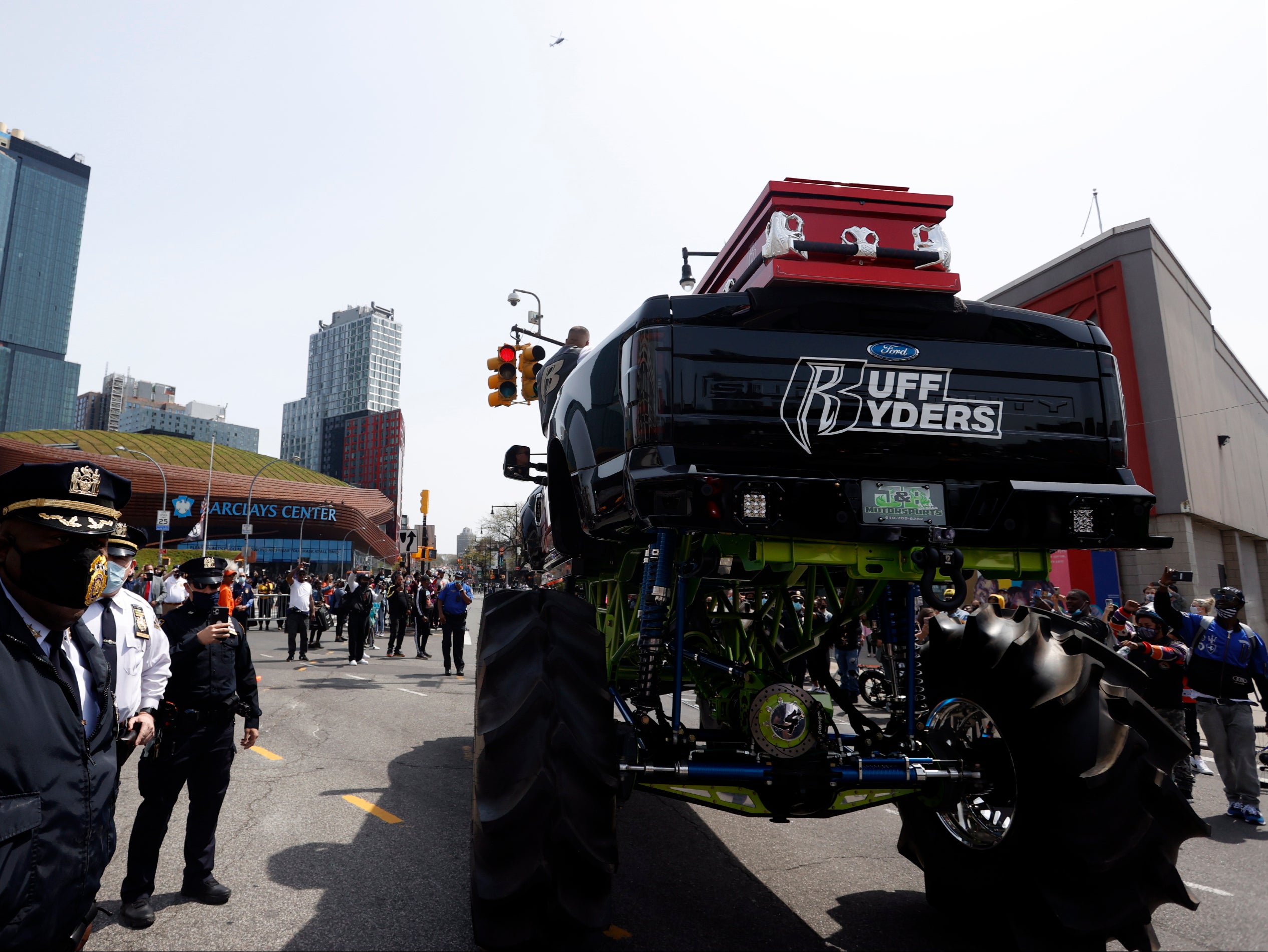 Members of the NYPD stand next to the monster truck holding the casket of US rapper DMX on Flatbush avenue outside the Barclays Center.