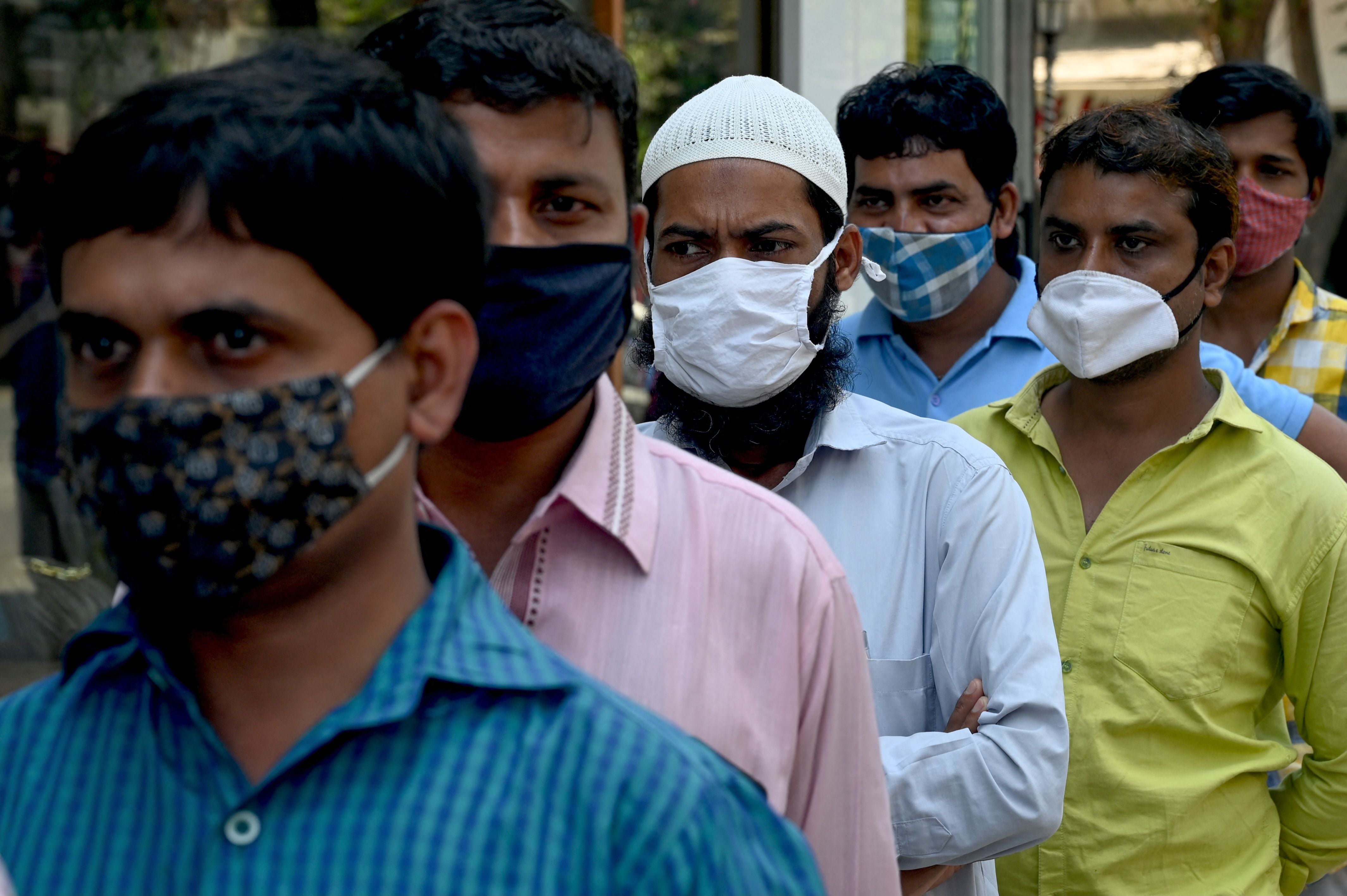 People wait in a queue to get a Rapid Antigen Testing (RAT) at a roadside market following restrictions imposed by the state government