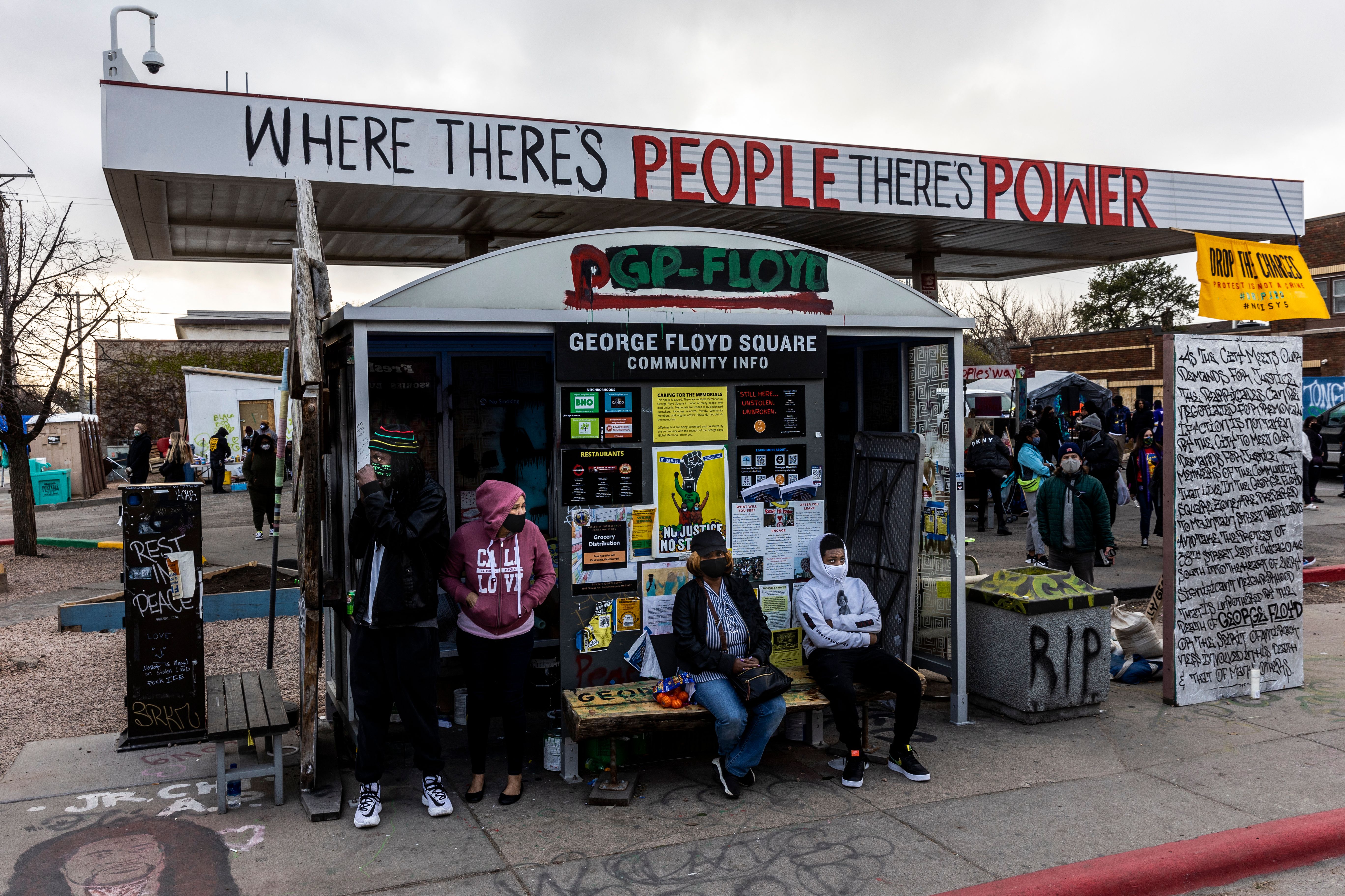 People sit at a bus stop at George Floyd Square in Minneapolis, Minnesota on April 21, 2021, a day after Derek Chauvin was convicted of Floyd's murder. - The conviction of white officer Derek Chauvin for George Floyd's murder raised hopes on April 21 in the Black community of a historic turning point in US justice, but the police killing of another African American cast a shadow over prospects for change.