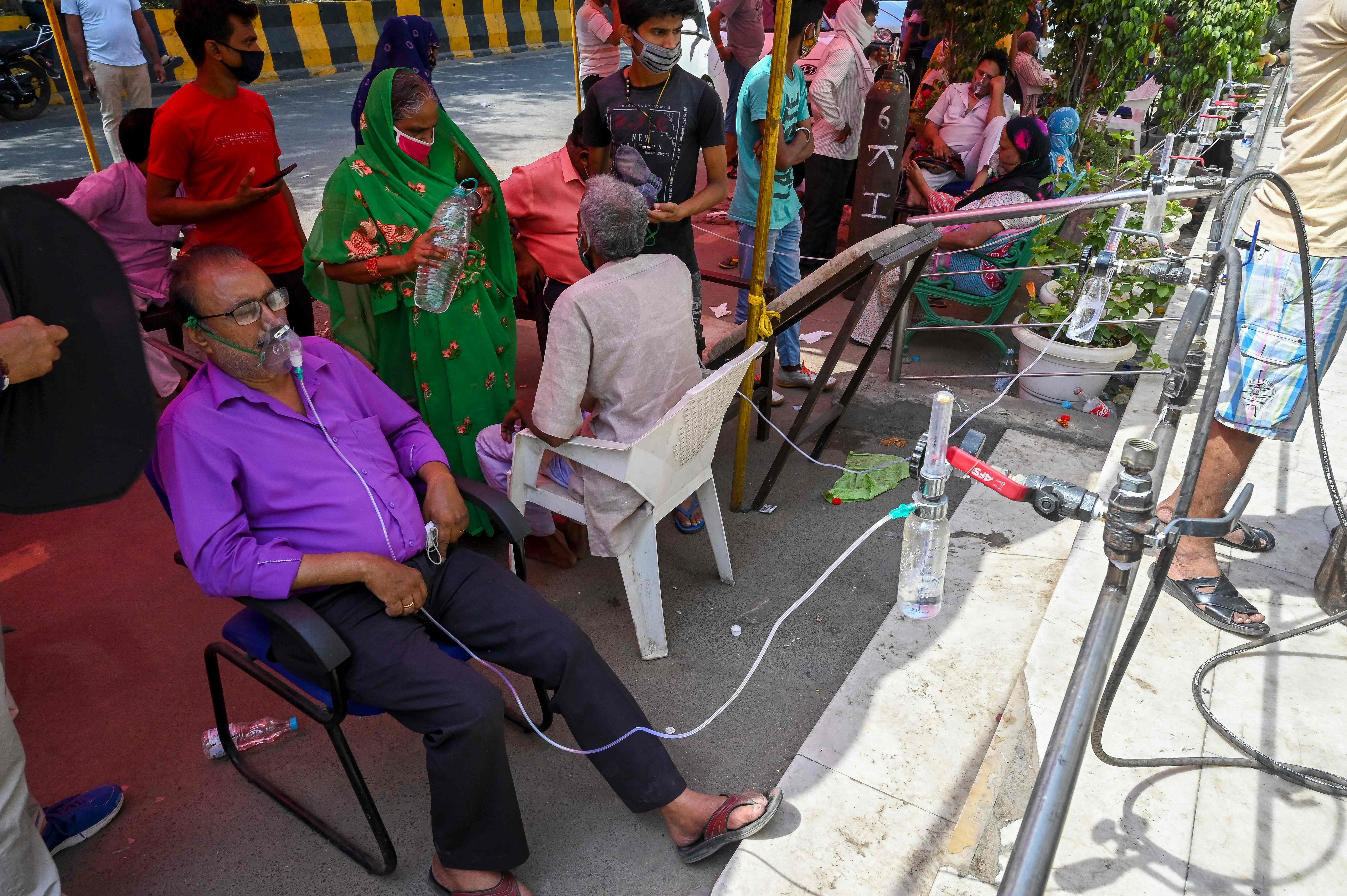 Covid-19 coronavirus patients breathe with the help of oxygen provided by a Gurdwara, a place of worship for Sikhs, under a tent installed along the roadside in Ghaziabad, Uttar Pradesh