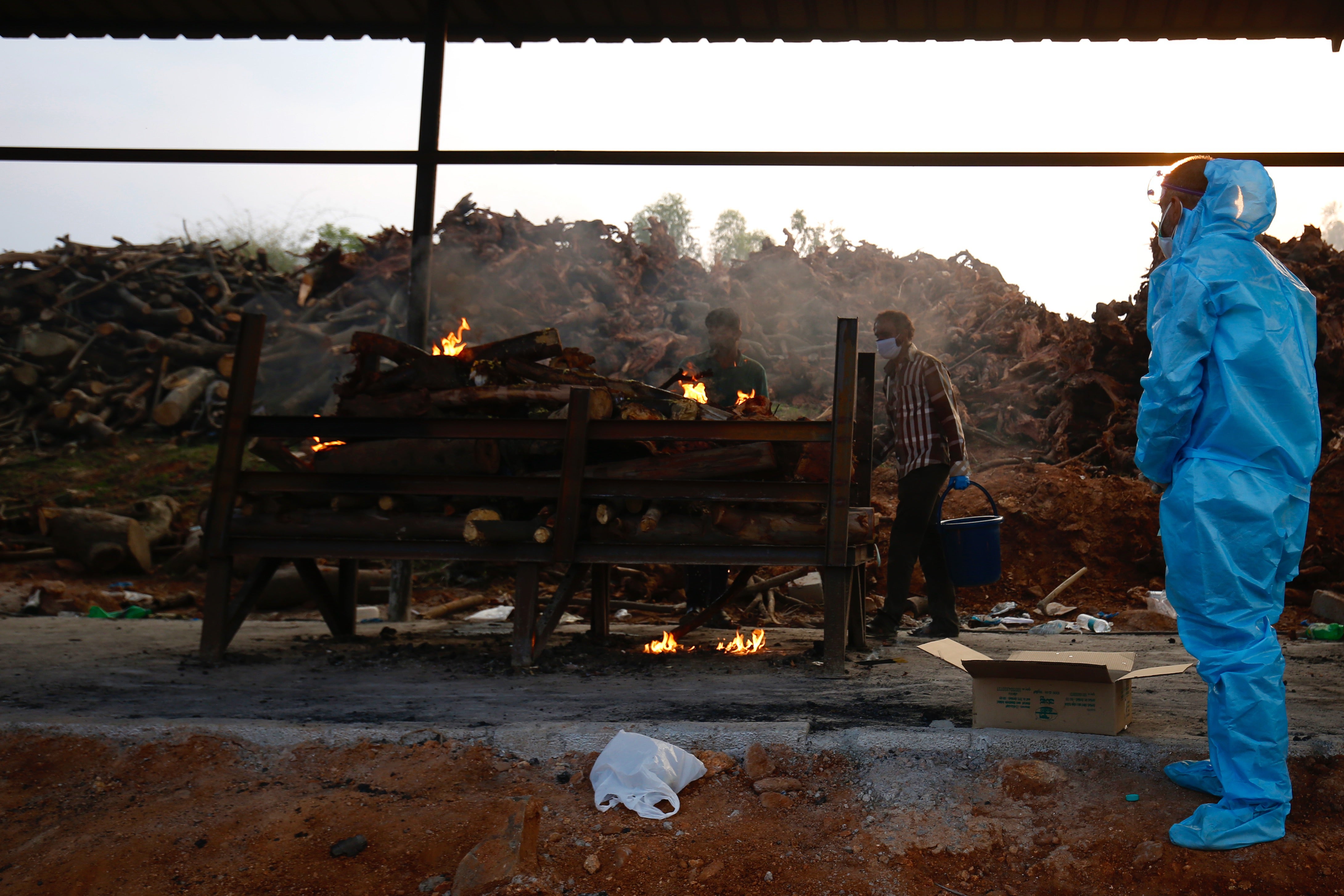 A man wearing PPE (Personal Protection Equipment) prays during the last rites of a deceased relative in a new crematorium built to cremate the dead due to Covid-19