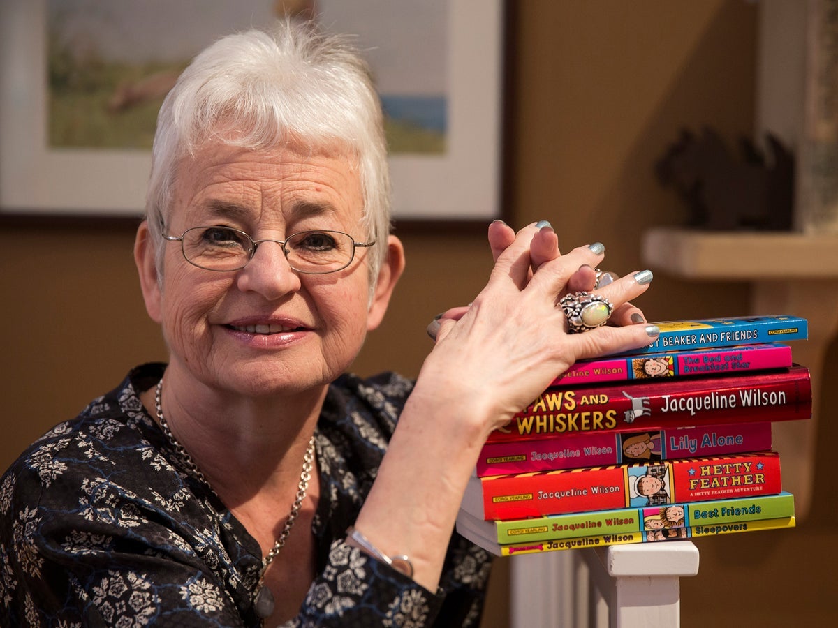 Dame Jacqueline Wilson poses with a pile of her books