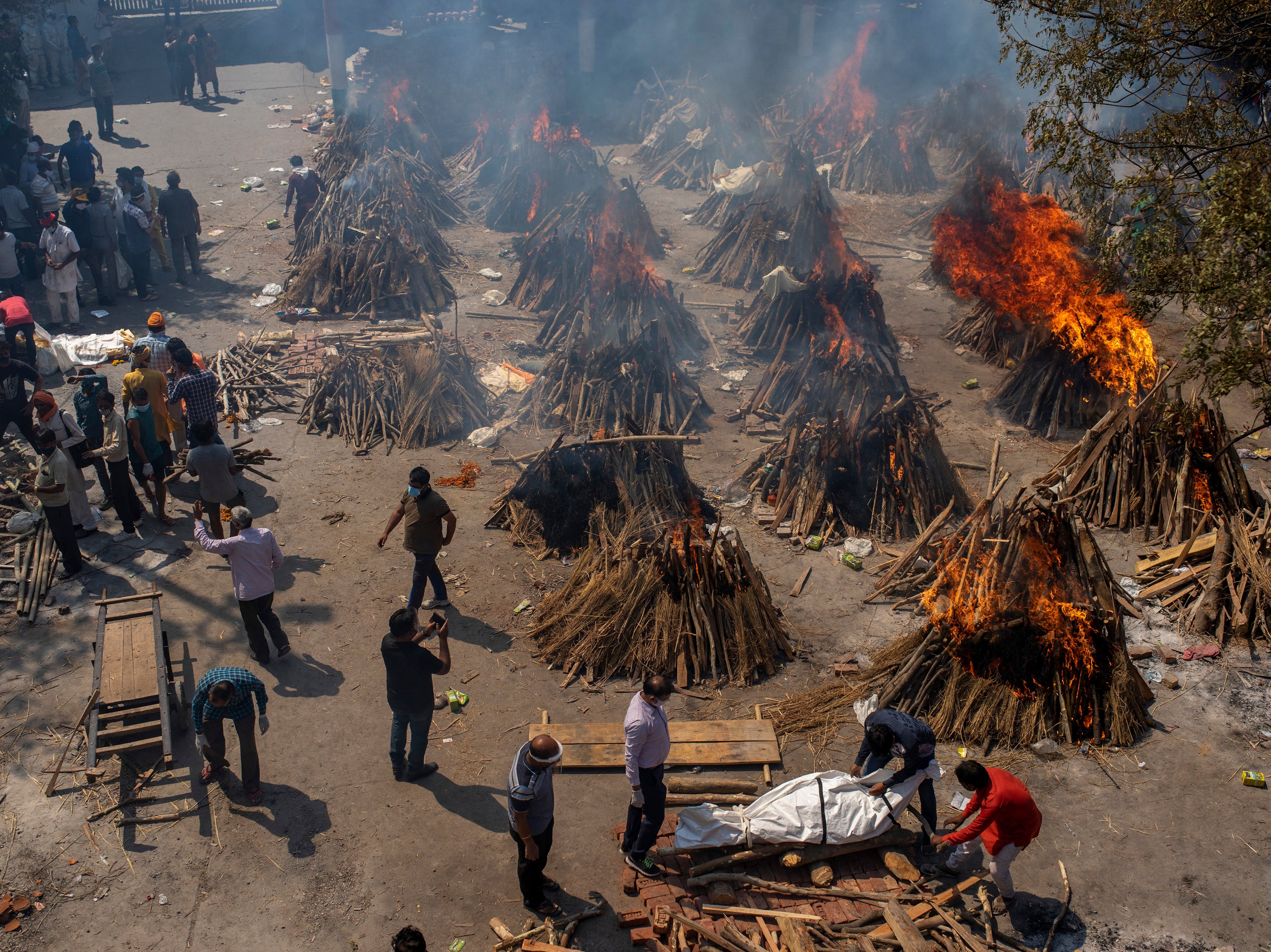 Multiple funeral pyres of Covid-19 victims burn at a site converted into a crematorium for mass cremation in New Delhi, India
