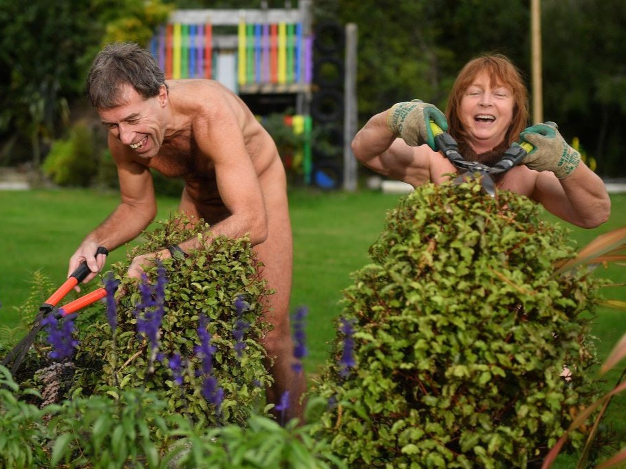 Brent Anderson (L) and Robyn Beach trim some bushes as they participate in World Naked Gardening Day at the Wellington Naturist Club in 2018