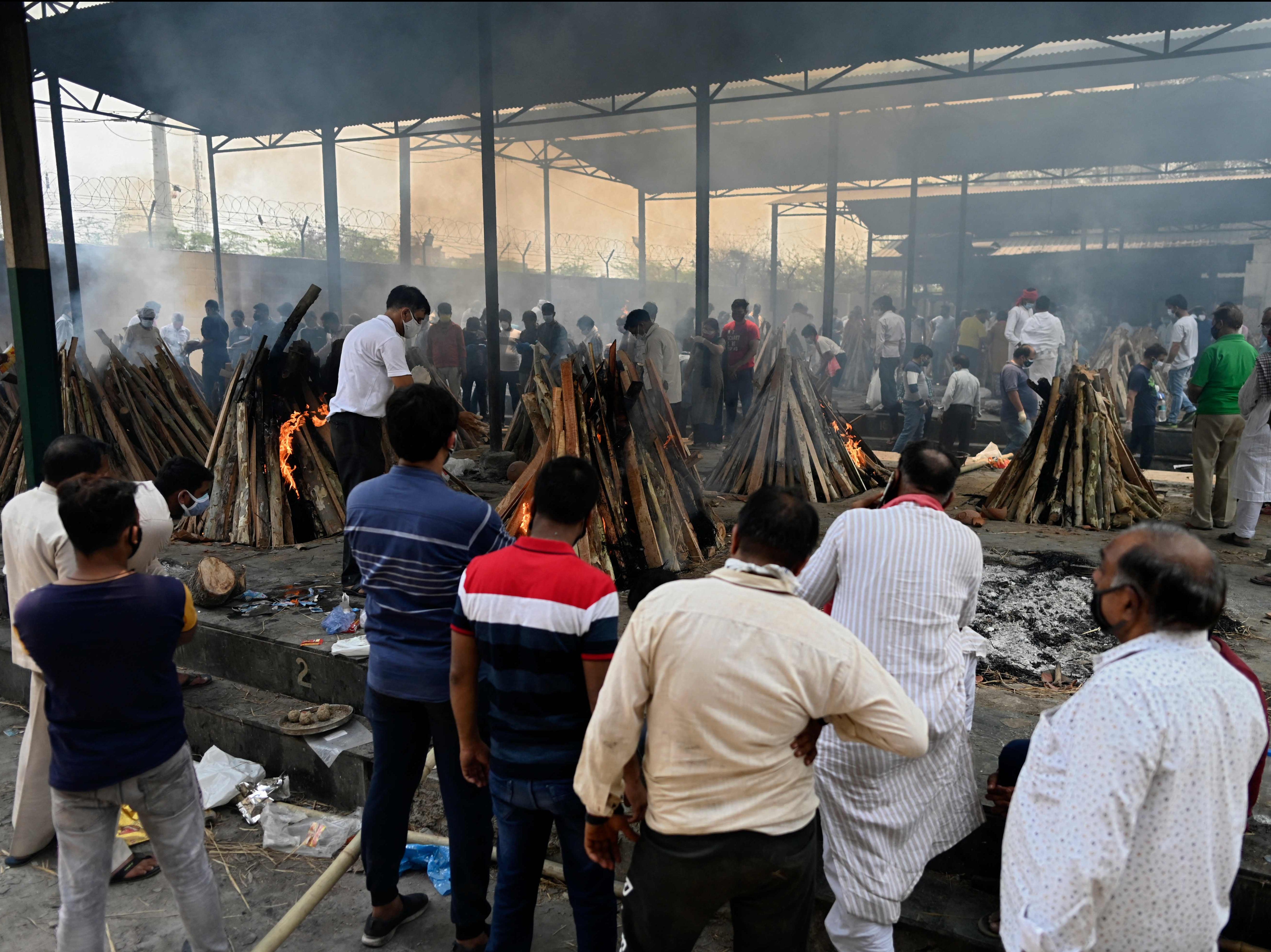 Relatives perform the last rites of a coronavirus victim at a crematorium in Ghazipur