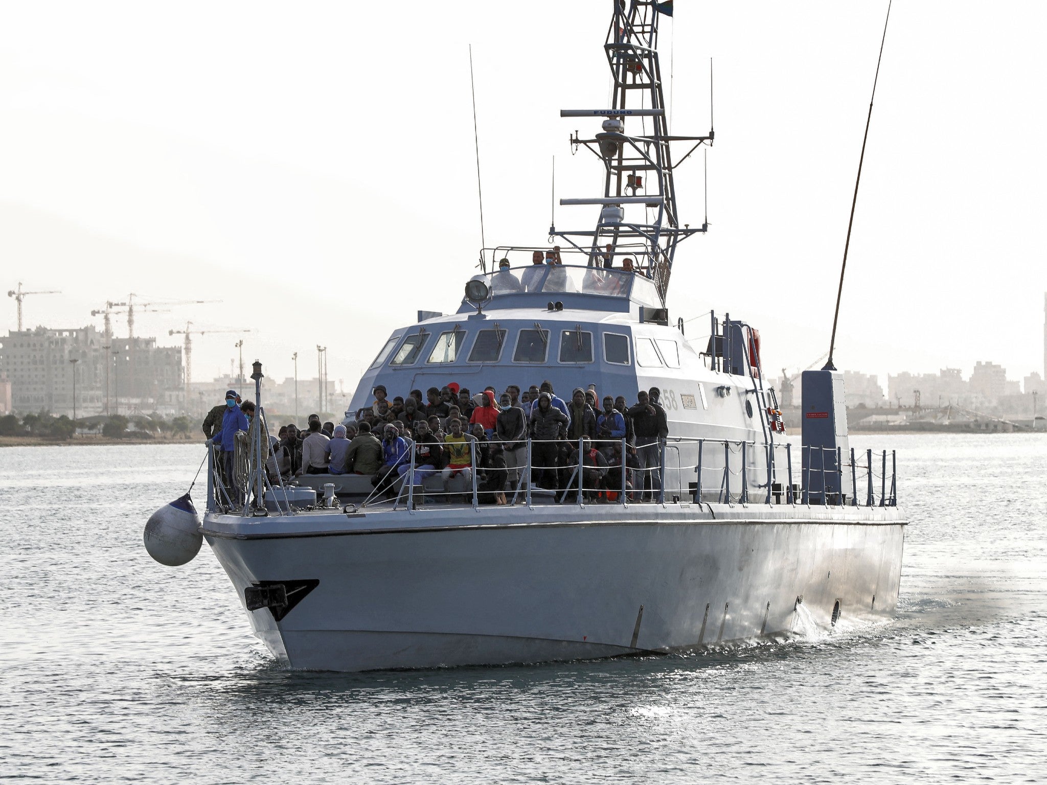 Refugees and migrants arrive at the naval base in the Libyan capital of Tripoli having been picked up at sea