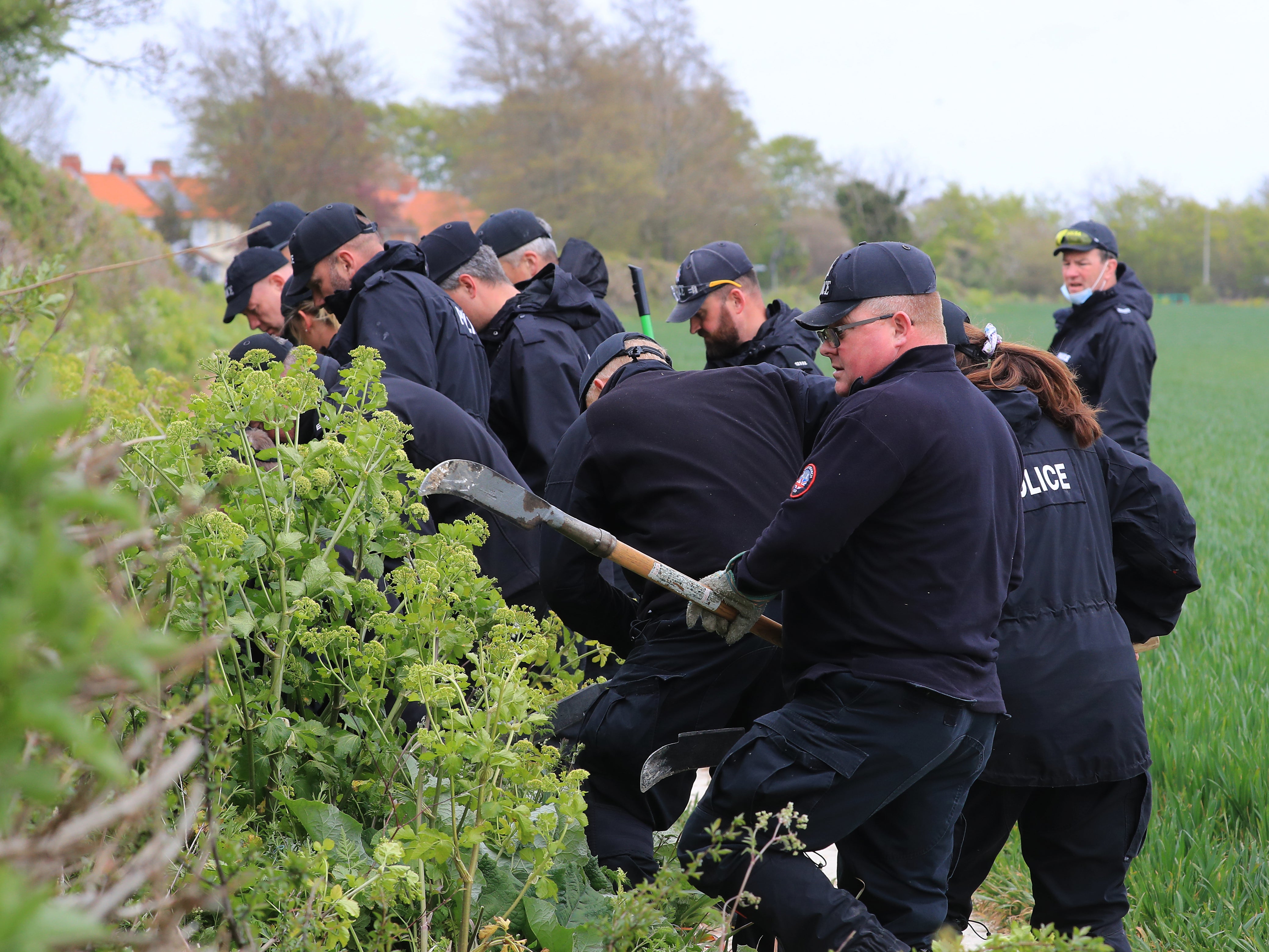 Police officers continue their search of fields close to the hamlet of Snowdown