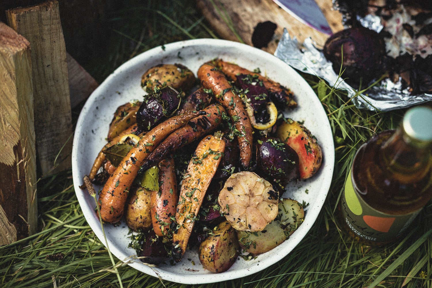 Ember-baked roots with garlic and carrot tops