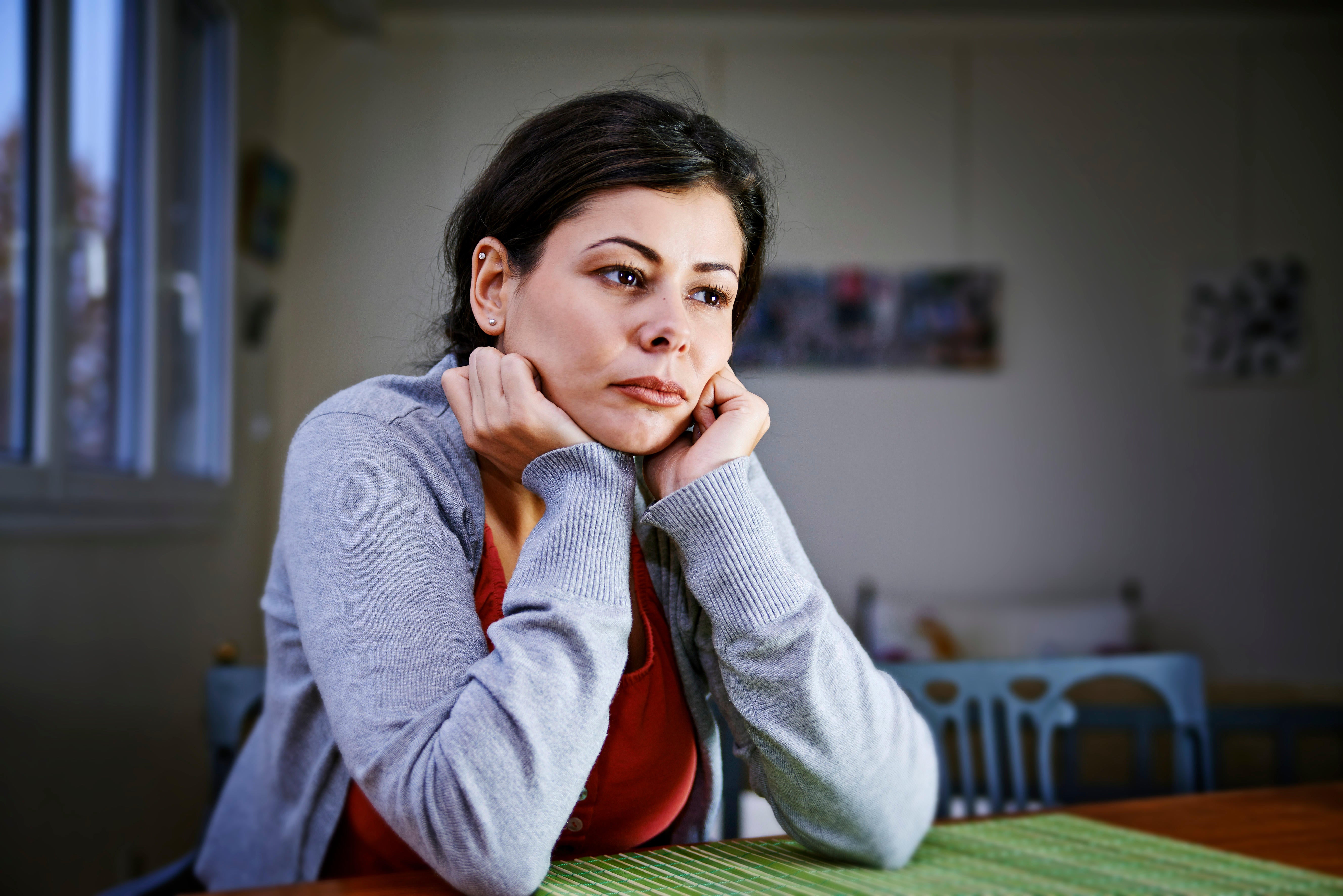 A woman sat at home, deep in thought