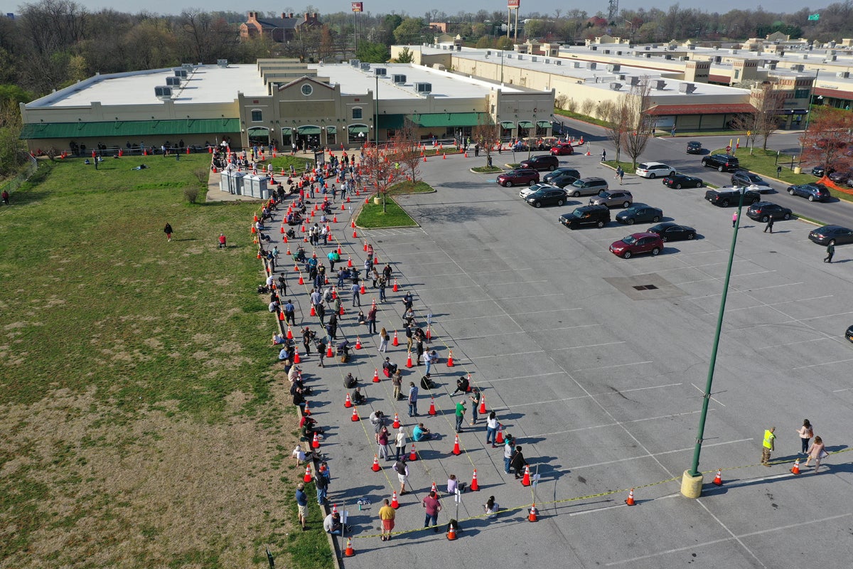 Hundreds of people with and without appointments stand in line outside the mass vaccination site in Maryland