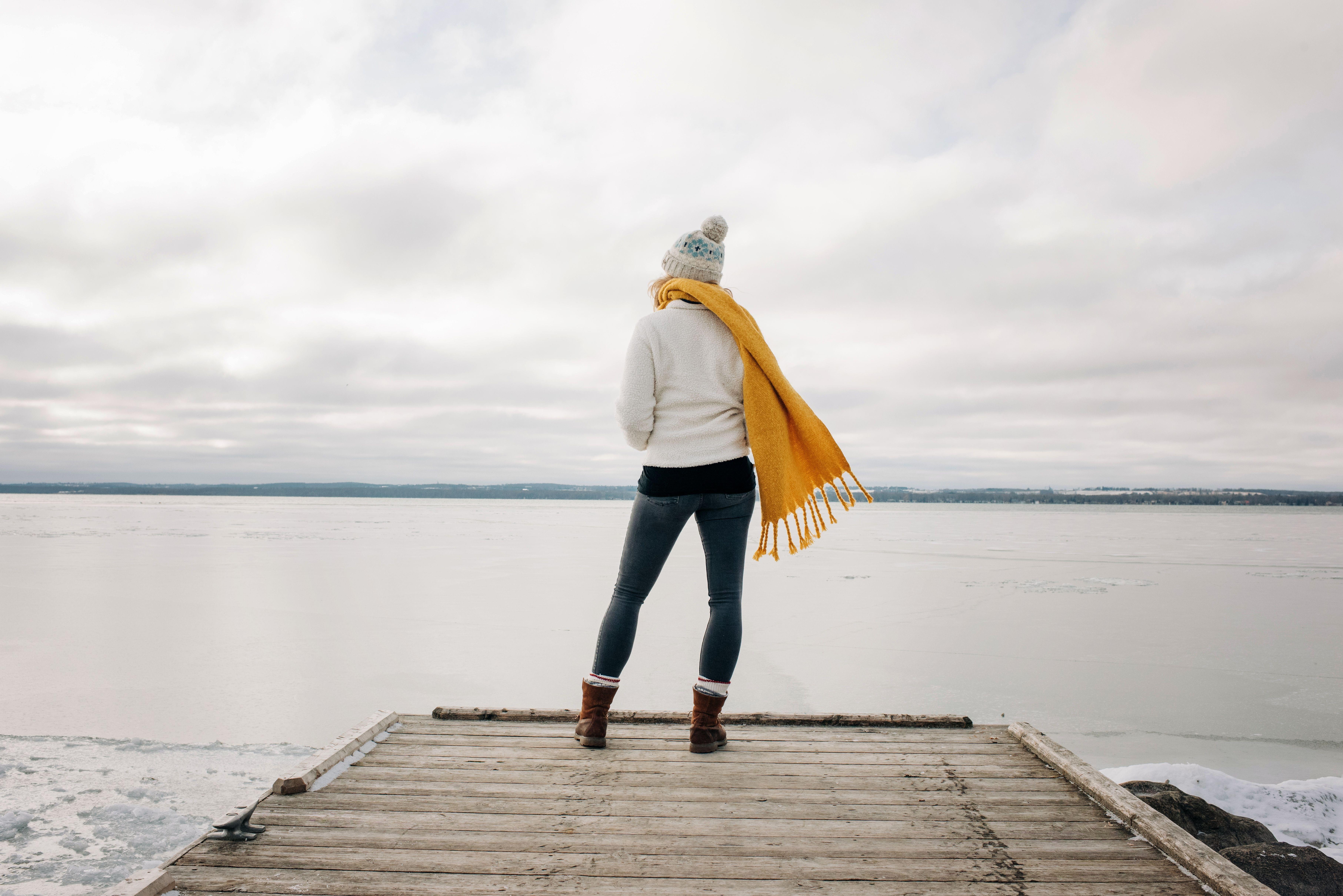 woman standing on the end of a pier