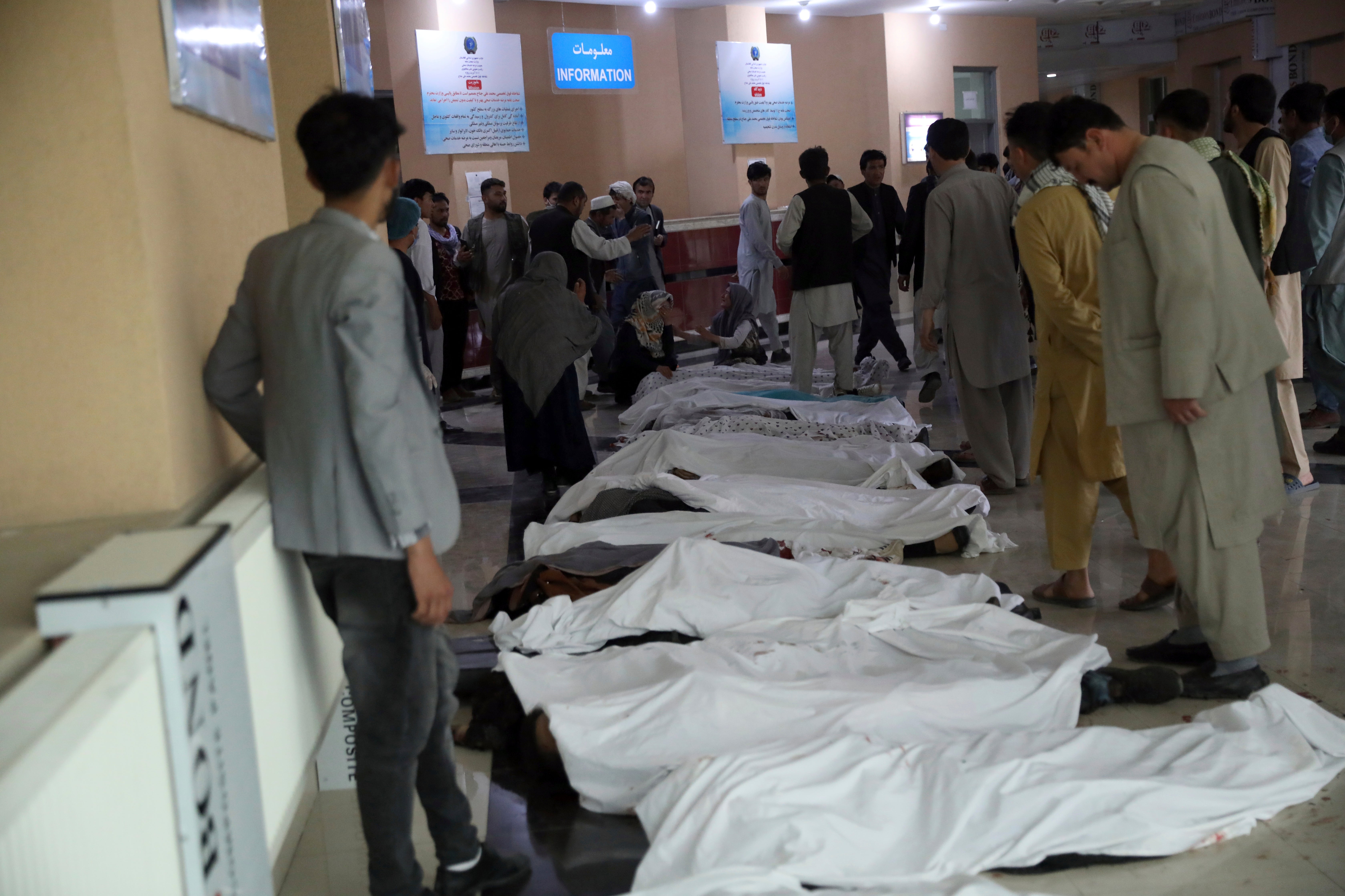 Relatives try to identify bodies at a hospital after the bomb near a school in Kabul, Afghanistan