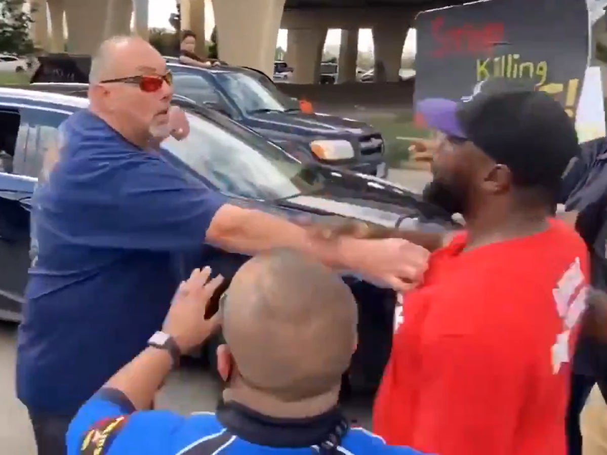 An unidentified man can be heard screaming obscenities at protesters as they stand in the road