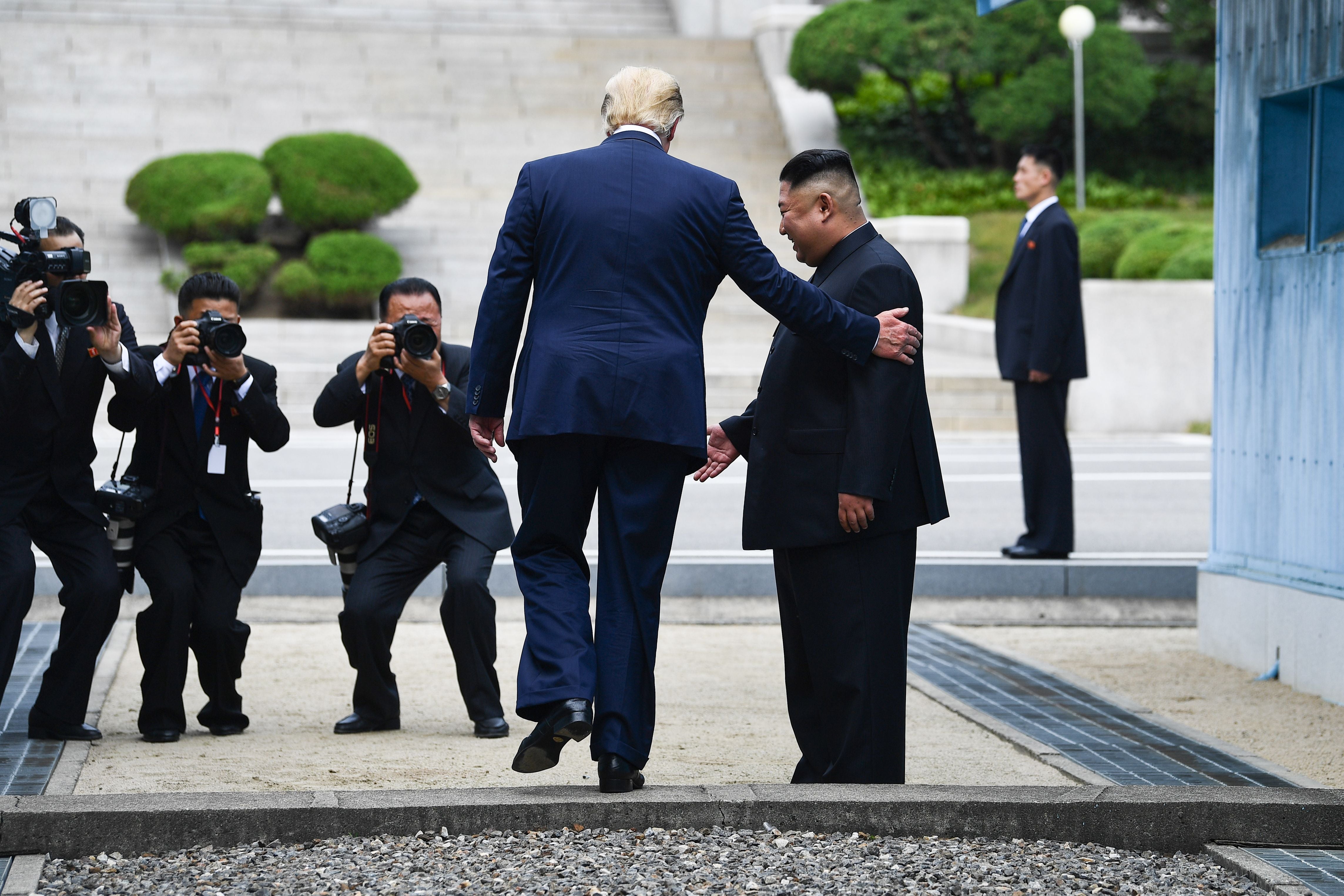 US President Donald Trump steps into the northern side of the Military Demarcation Line that divides North and South Korea, as North Korea's leader Kim Jong Un looks on, in the Joint Security Area (JSA) of Panmunjom in the Demilitarized zone (DMZ) on June 30, 2019