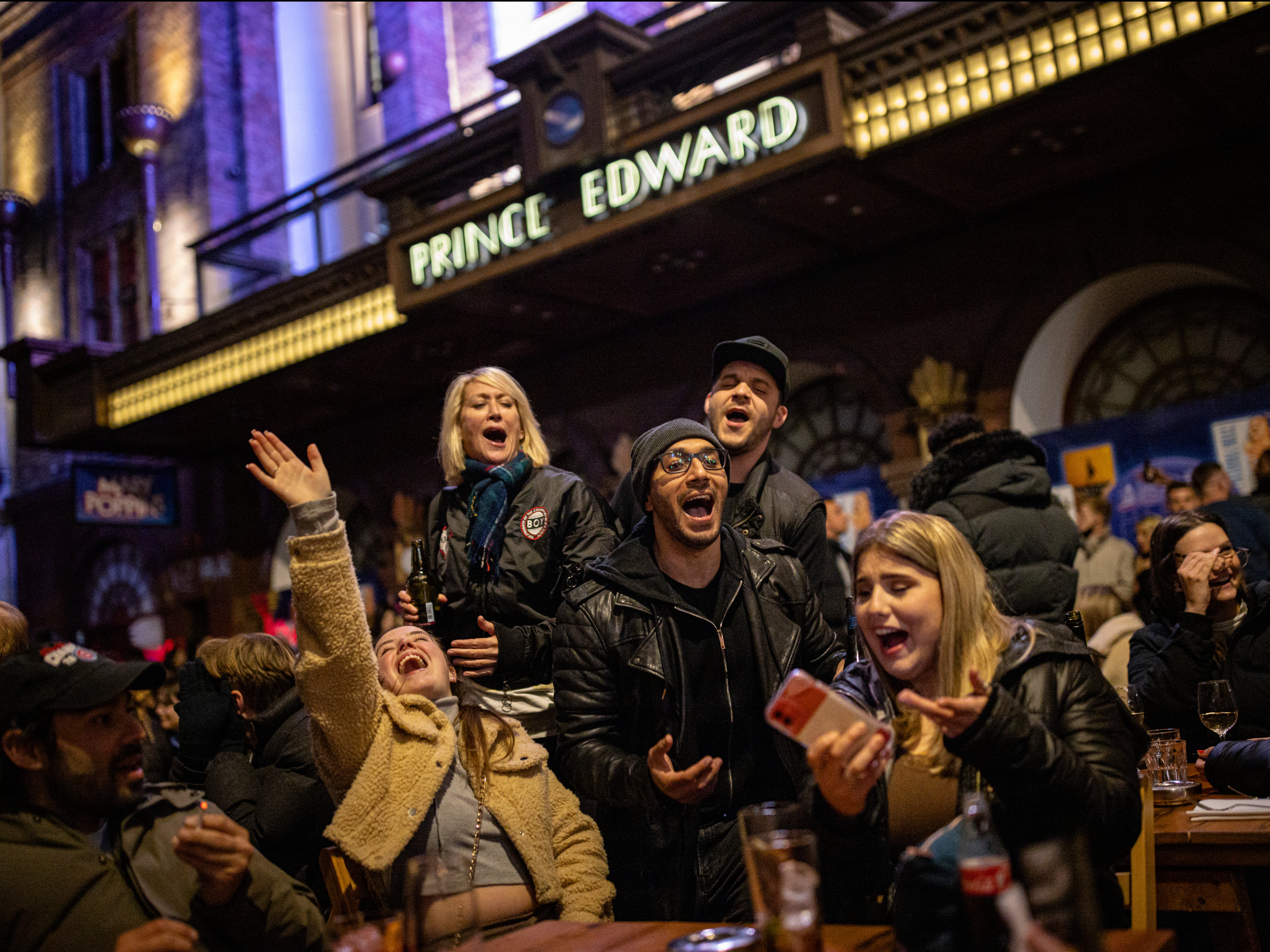 A group of people sing Happy Birthday while enjoying drinks on Old Compton Street in Soho