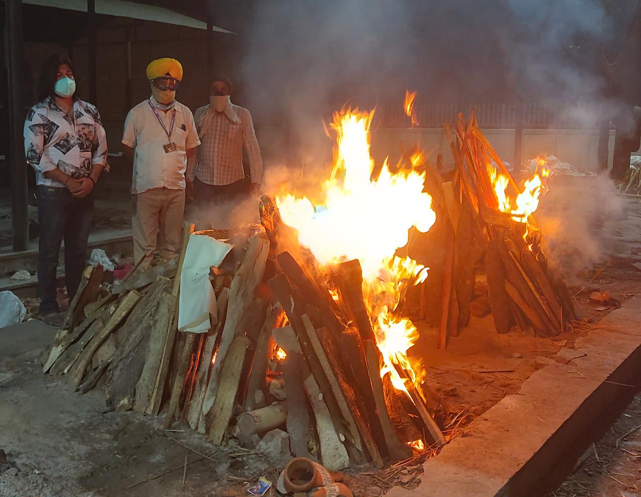 Former Indian politician Jitender Singh (in yellow turban) has helped hundreds of families in Delhi in carrying out cremation of their loved ones who died due to Covid-19