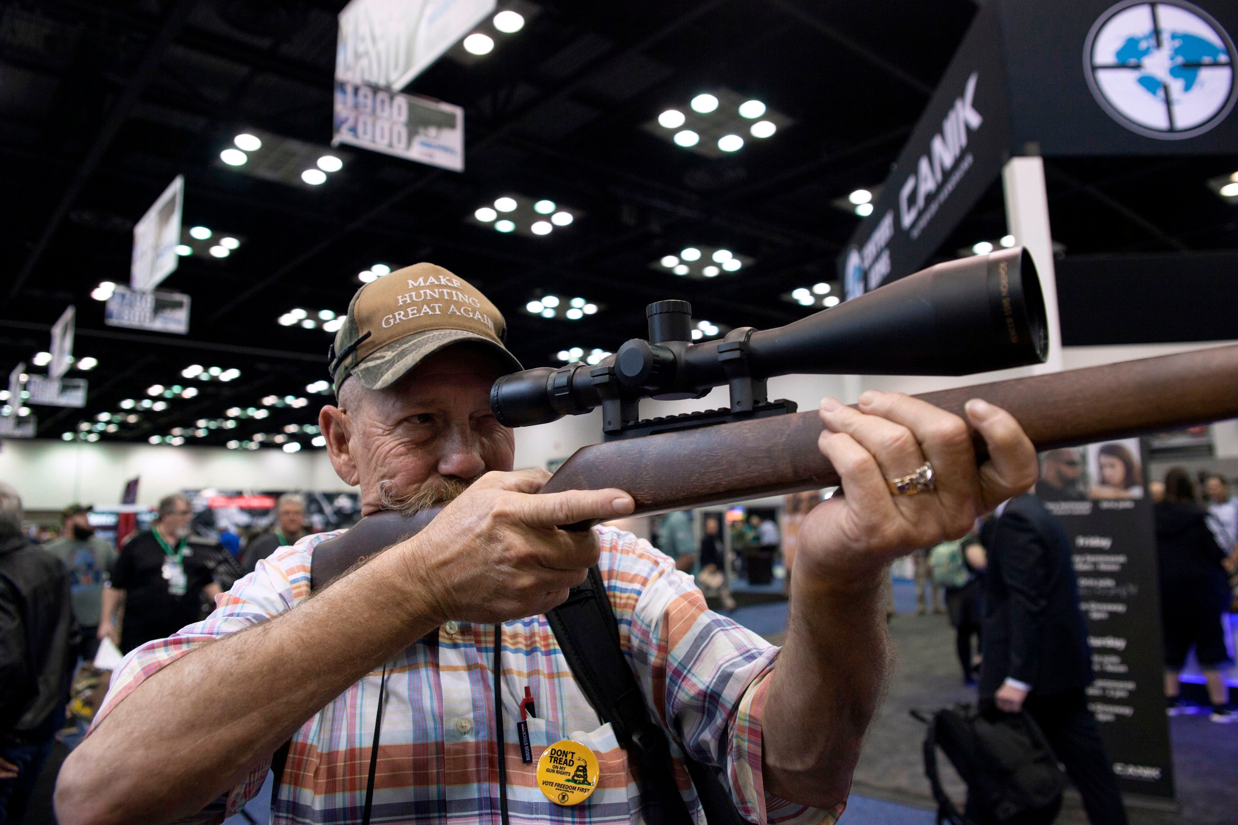 Mark McKenzie of Tulsa, Oklahoma, looks through the scope of a deactivated rifle at the 2019 National Rifle Association (NRA) Annual Meetings and Exhibits in Indianapolis, Indiana, on April 26, 2019.