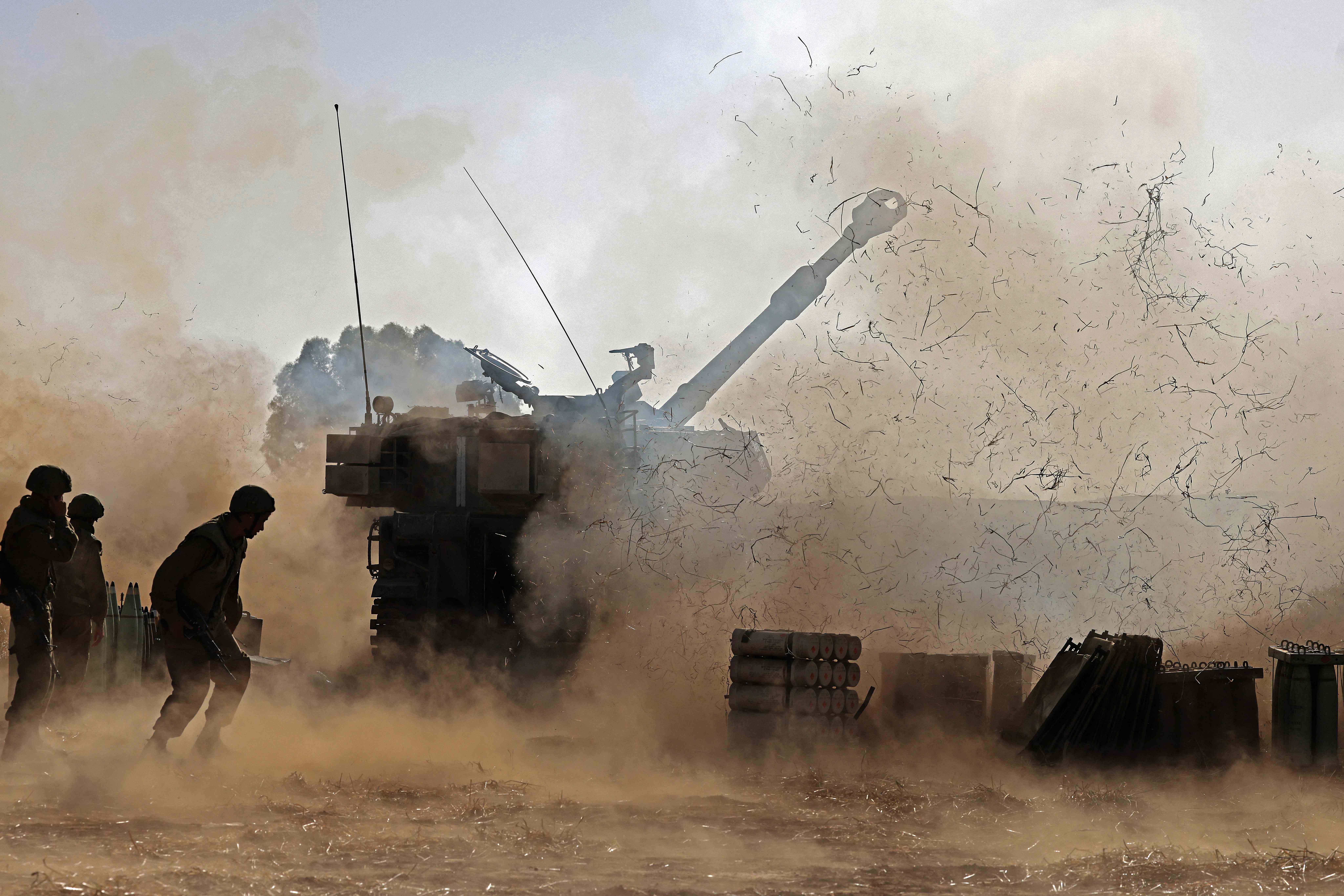 Israeli soldiers fire a 155mm self-propelled howitzer towards the Gaza Strip