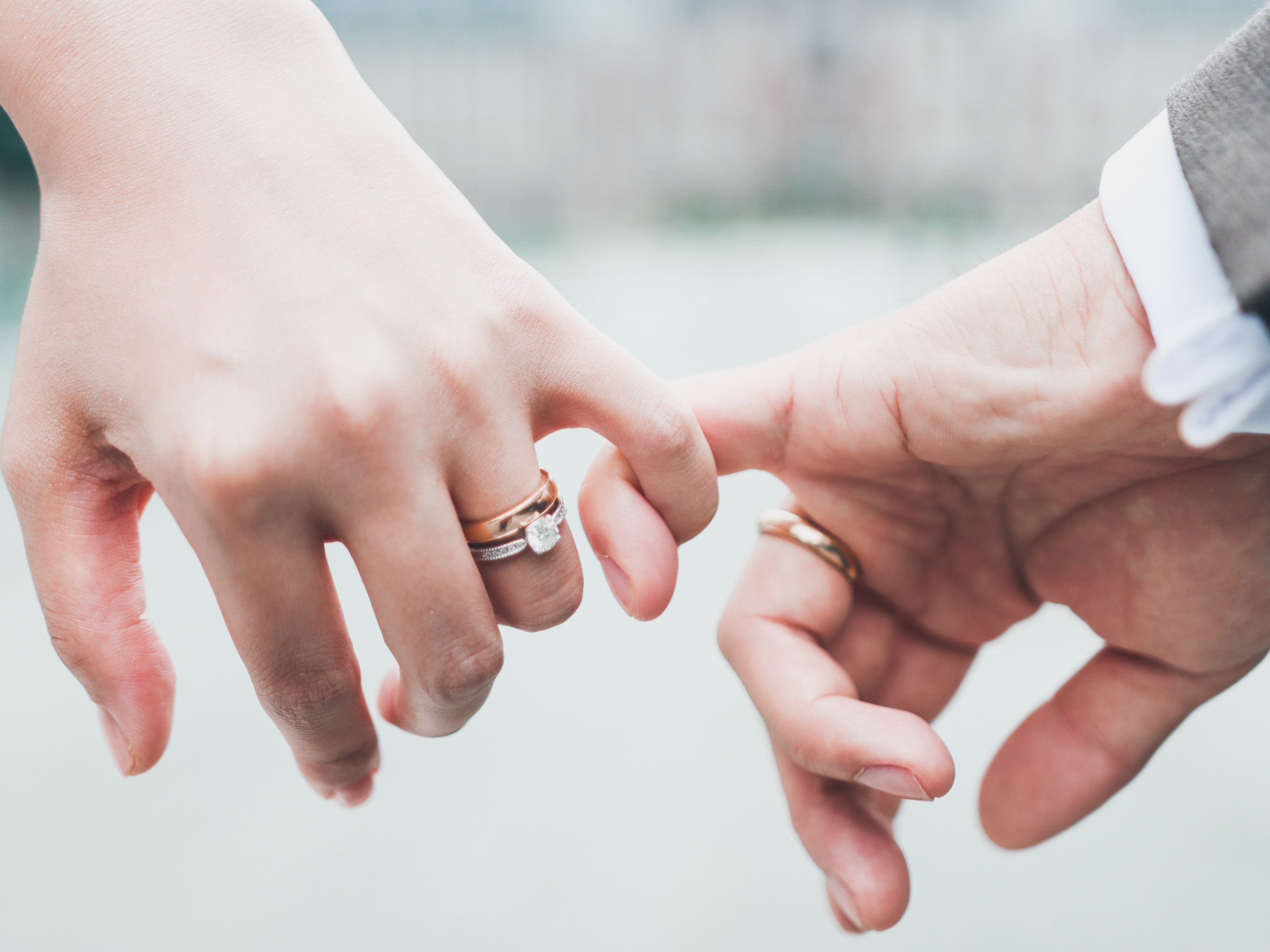 A newly wed couple doing a pinky promise