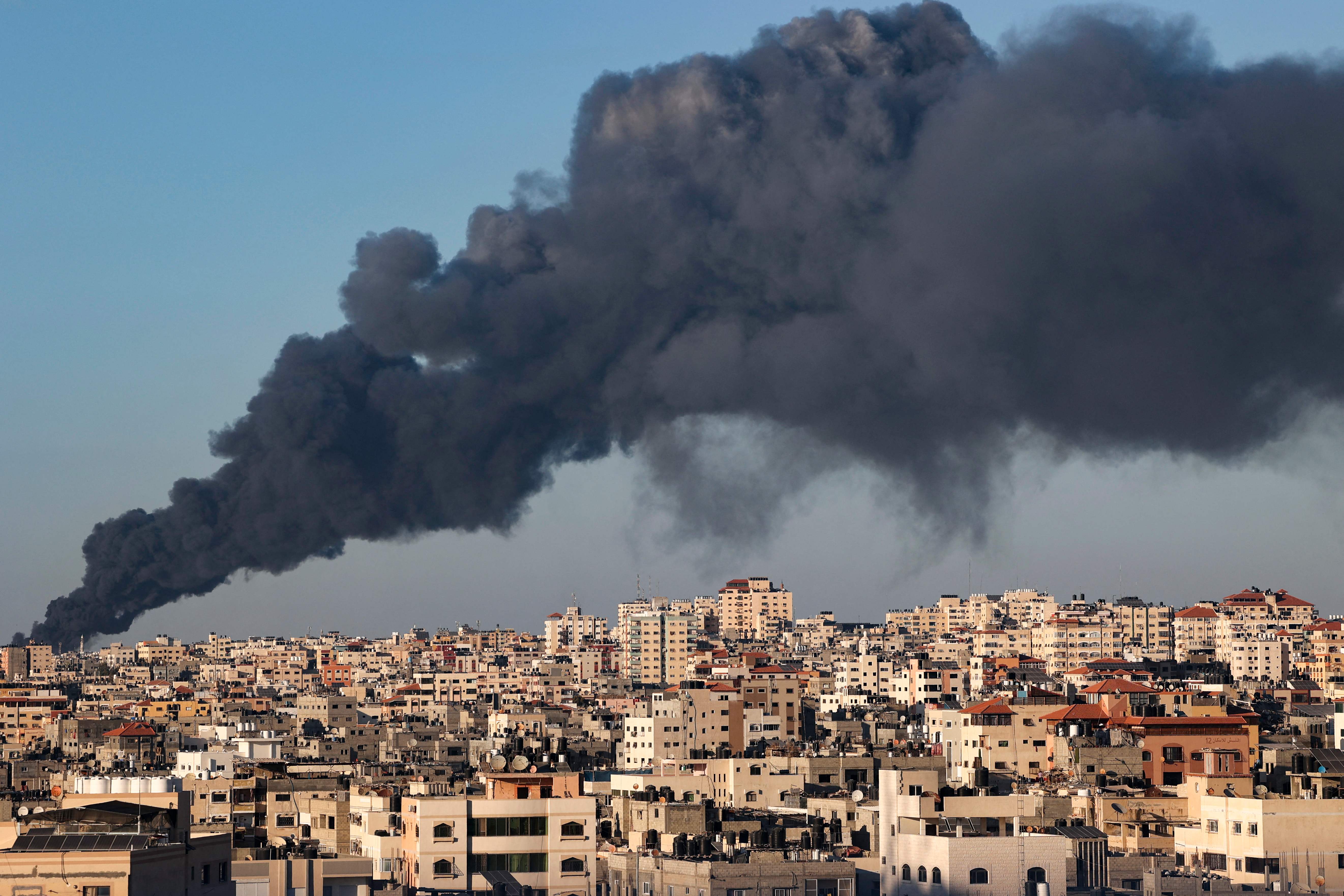 A plume of heavy black smoke rises above buildings in Gaza City from a fire caused by Israeli air strikes