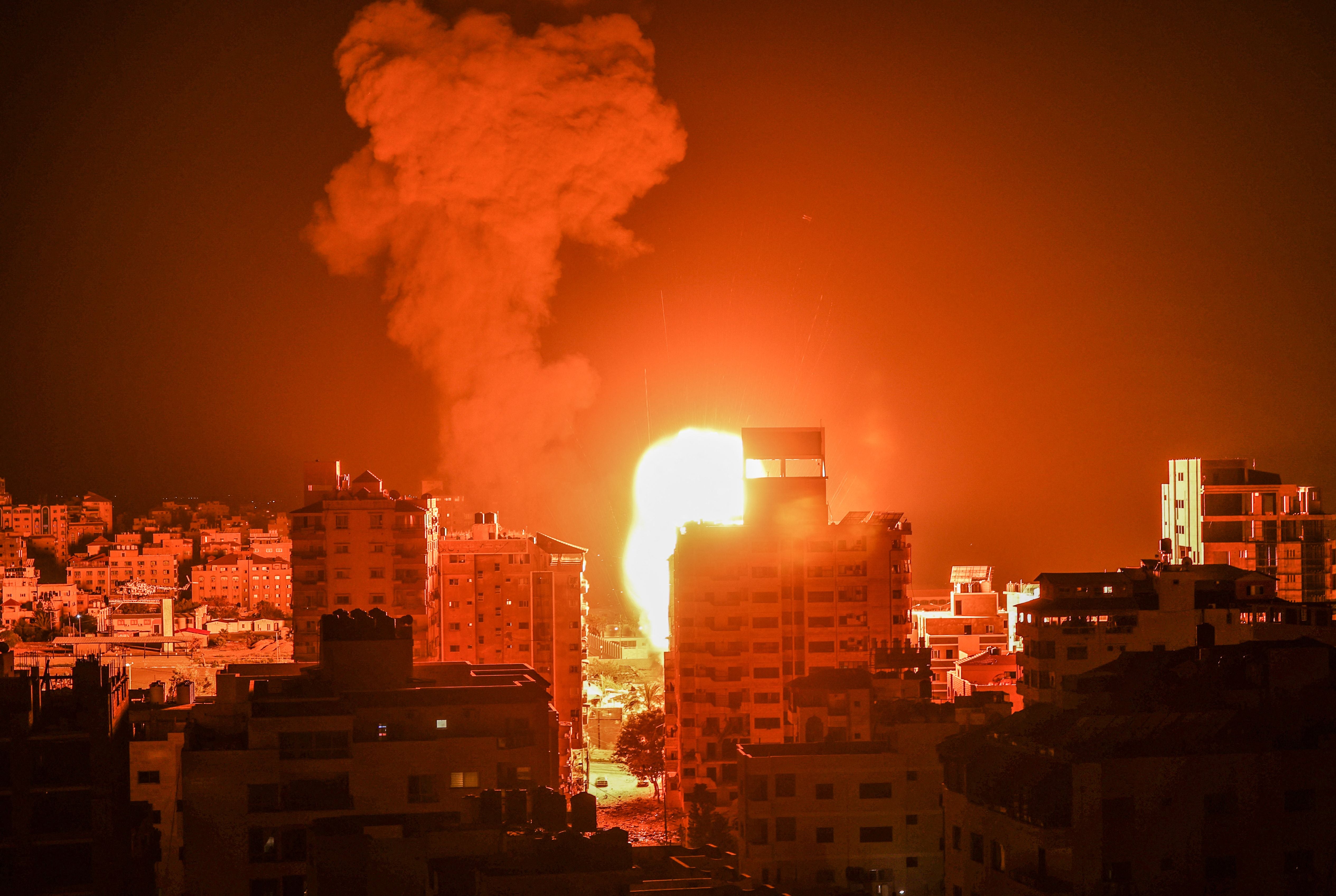 Fire and smoke rise above buildings in Gaza City as Israeli warplanes target Palestinian enclave on 17 May 2021