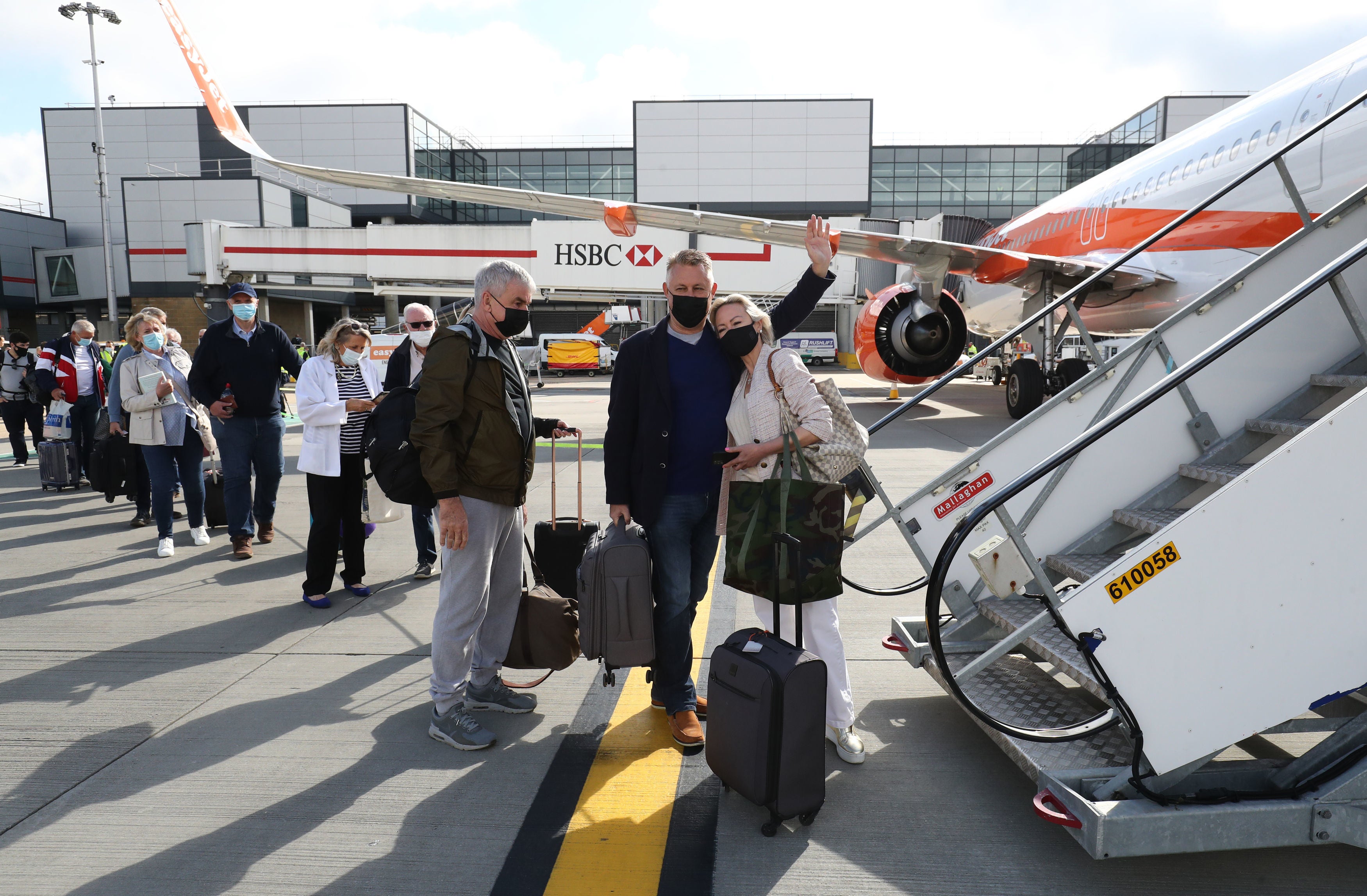 Passengers prepare to board an easyJet flight to Faro, Portugal, at Gatwick airport