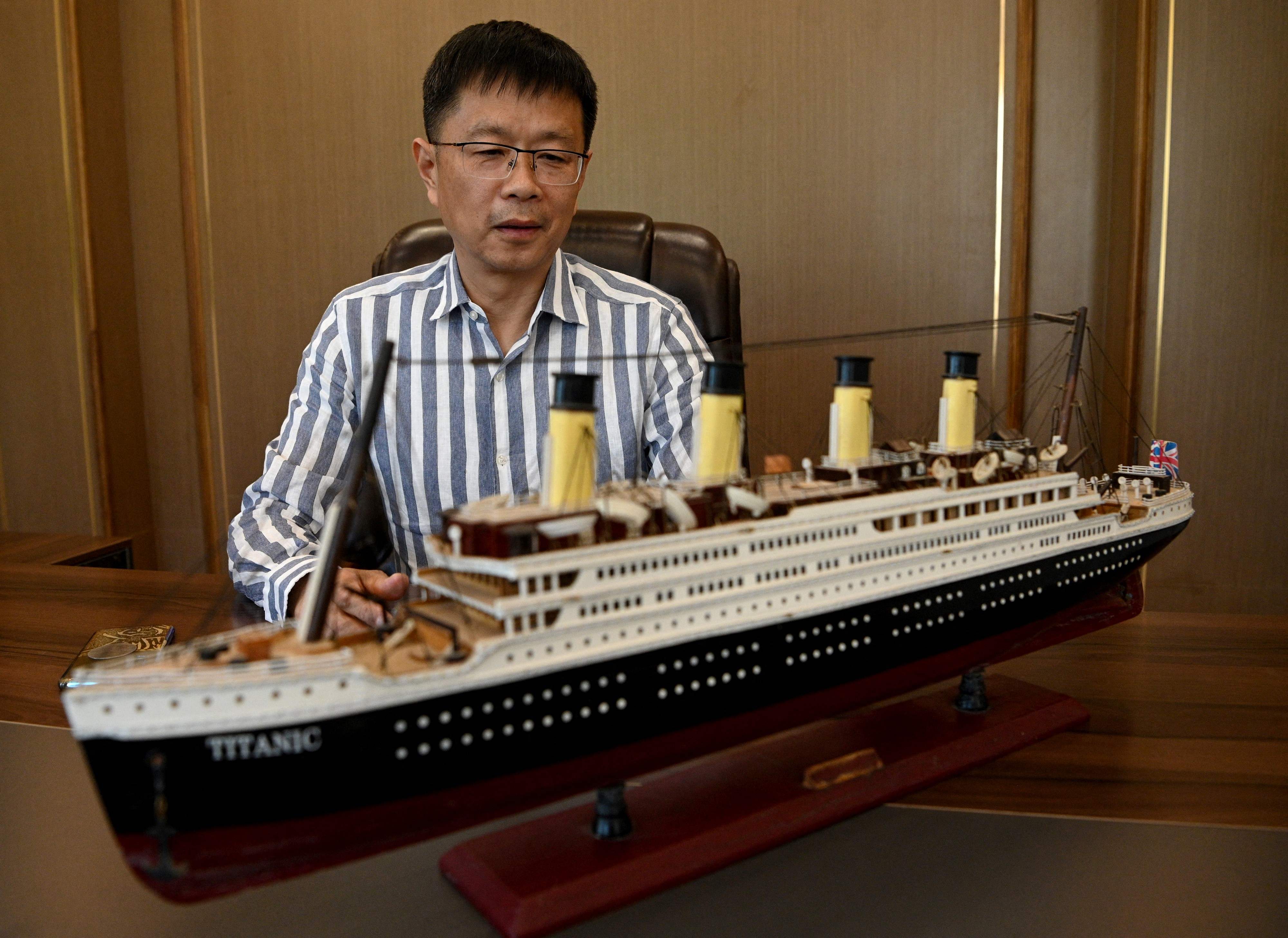 Su Shaojun next to a model of the Titanic