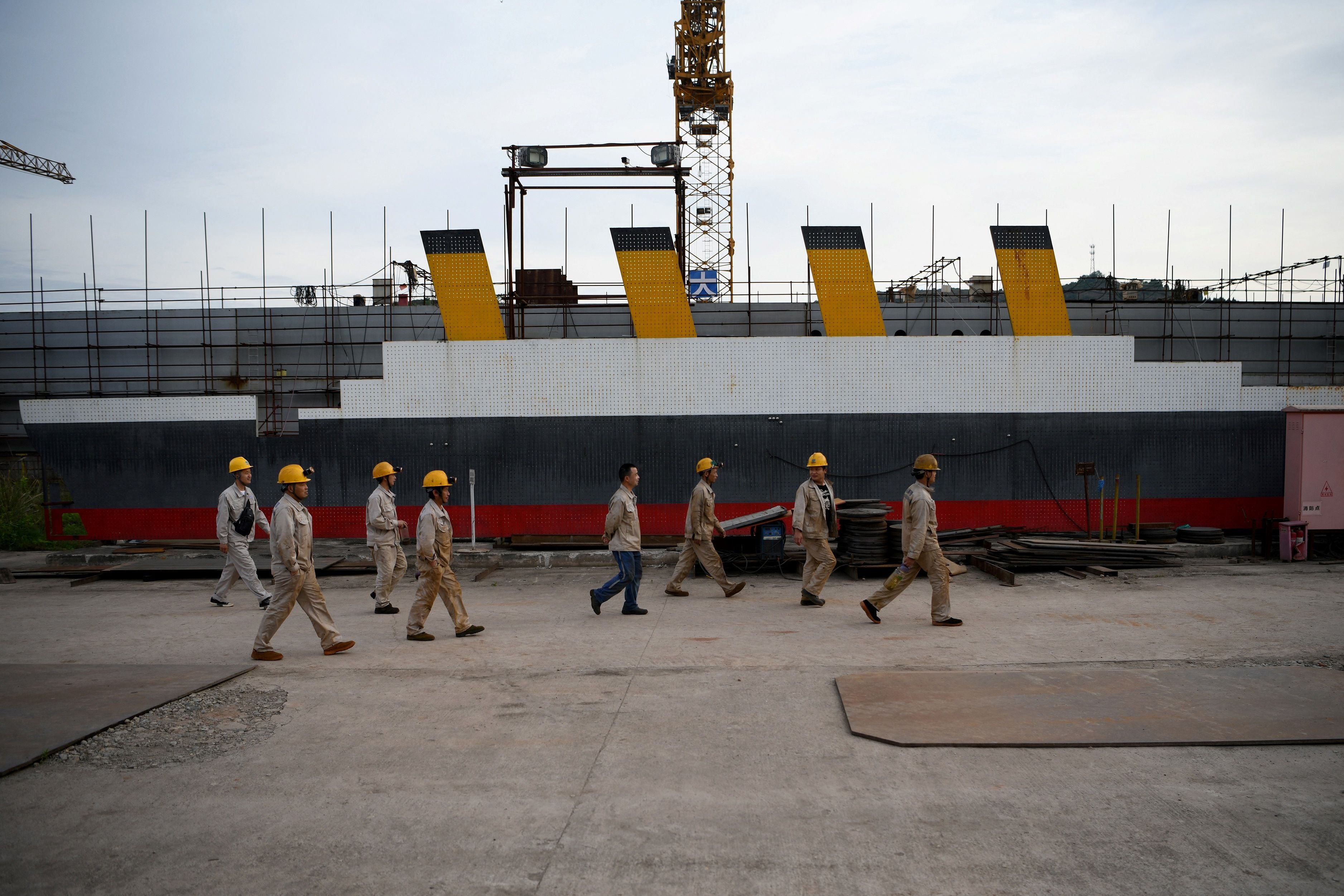 Workers arrive on site to continue building the replica