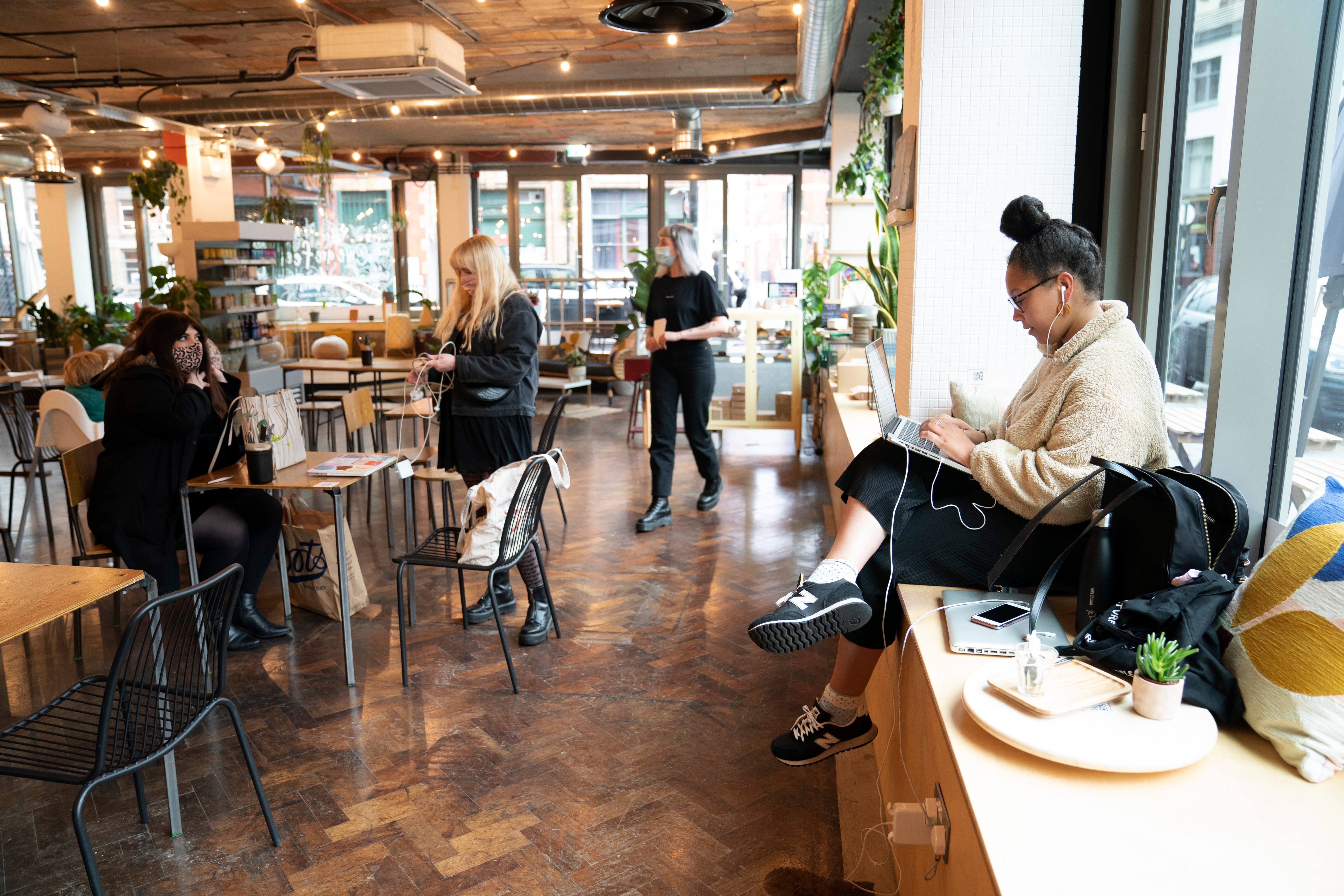 Members of the public sit in a cafe, as pubs, cafes and restaurants in England reopen indoors under the latest easing of the coronavirus lockdown