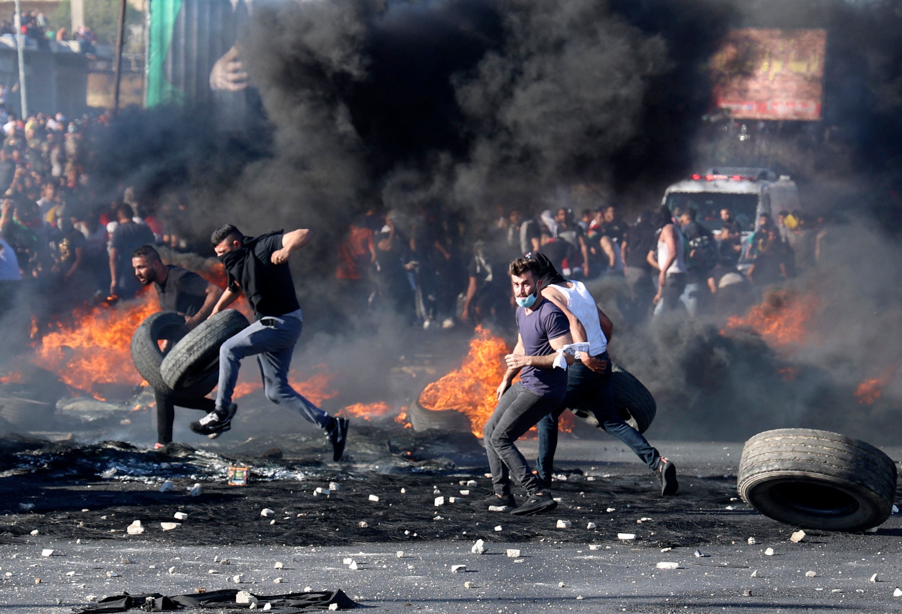 Palestinian protesters confront Israeli troops at the Hawara checkpoint south of Nablus city in the occupied West Bank