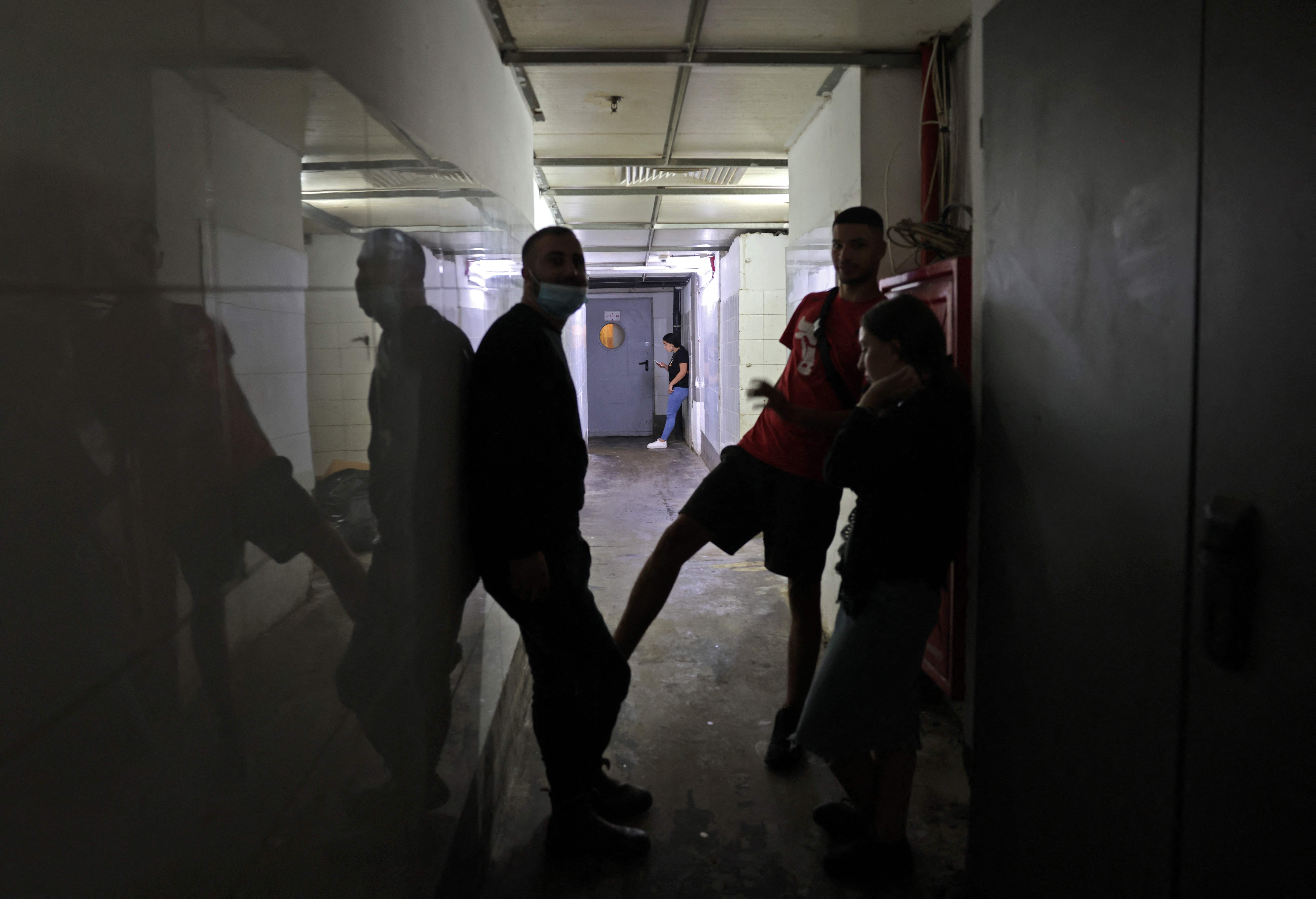 Israelis hide in the shelter of their building as rockets fired from the Gaza Strip fall on the southern Israeli city of Ashdod