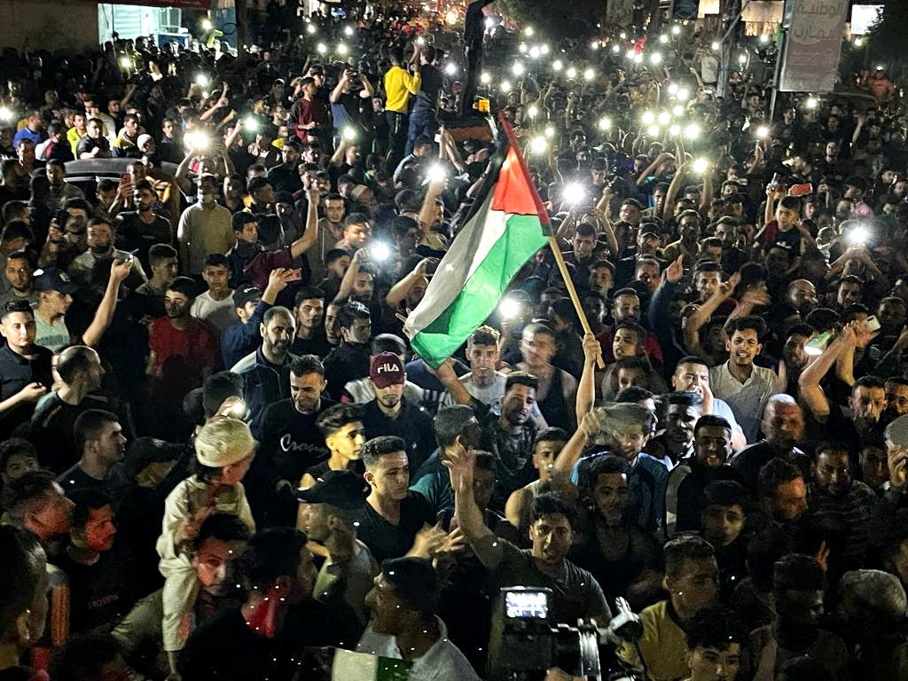 Palestinians celebrate in the streets following a ceasefire, in the southern Gaza Strip