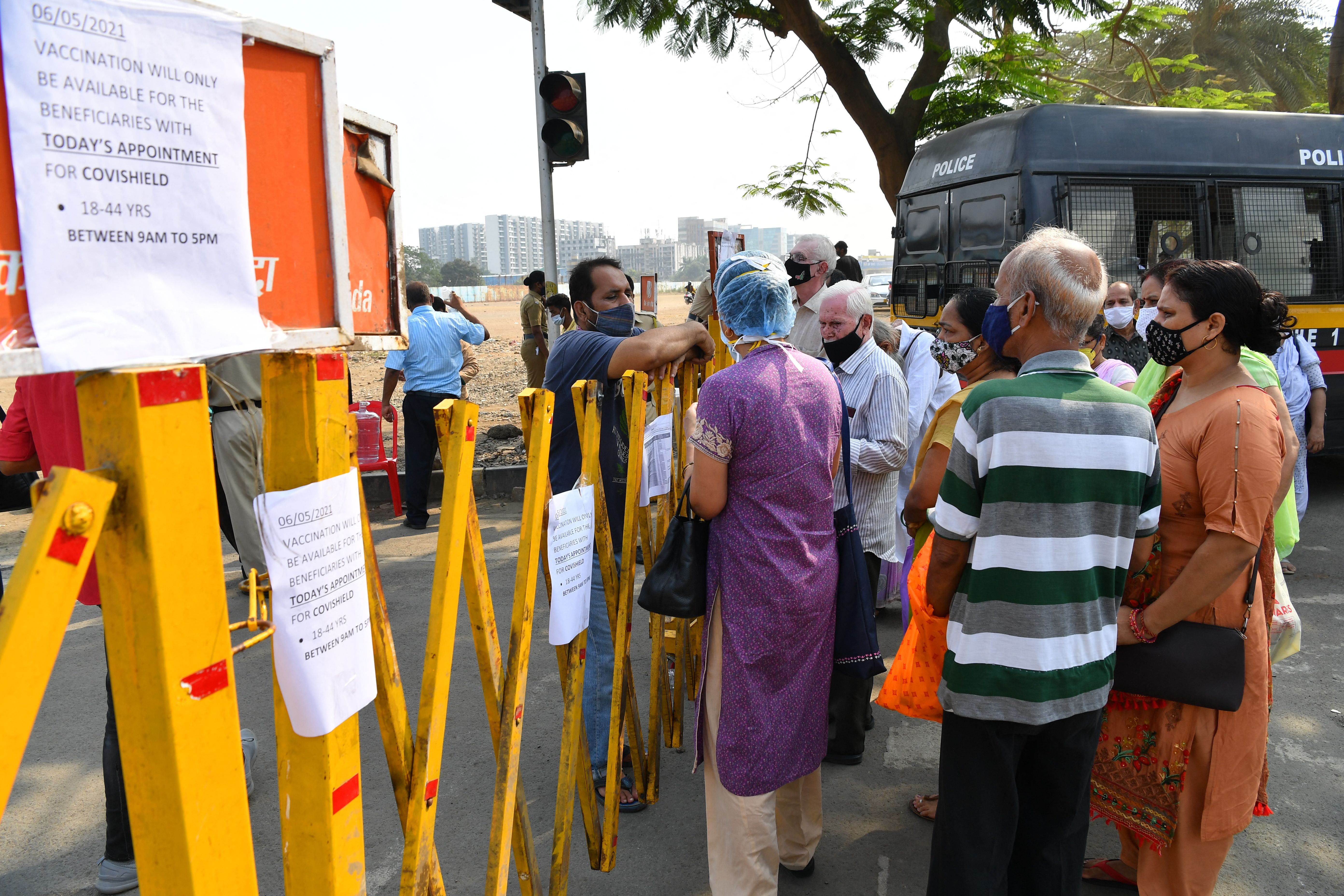 People over 45 years old talk to a staff member (L) after being turned down for their scheduled second vaccine dose due to stock shortages at a centre in Mumbai on 6 May, 2021