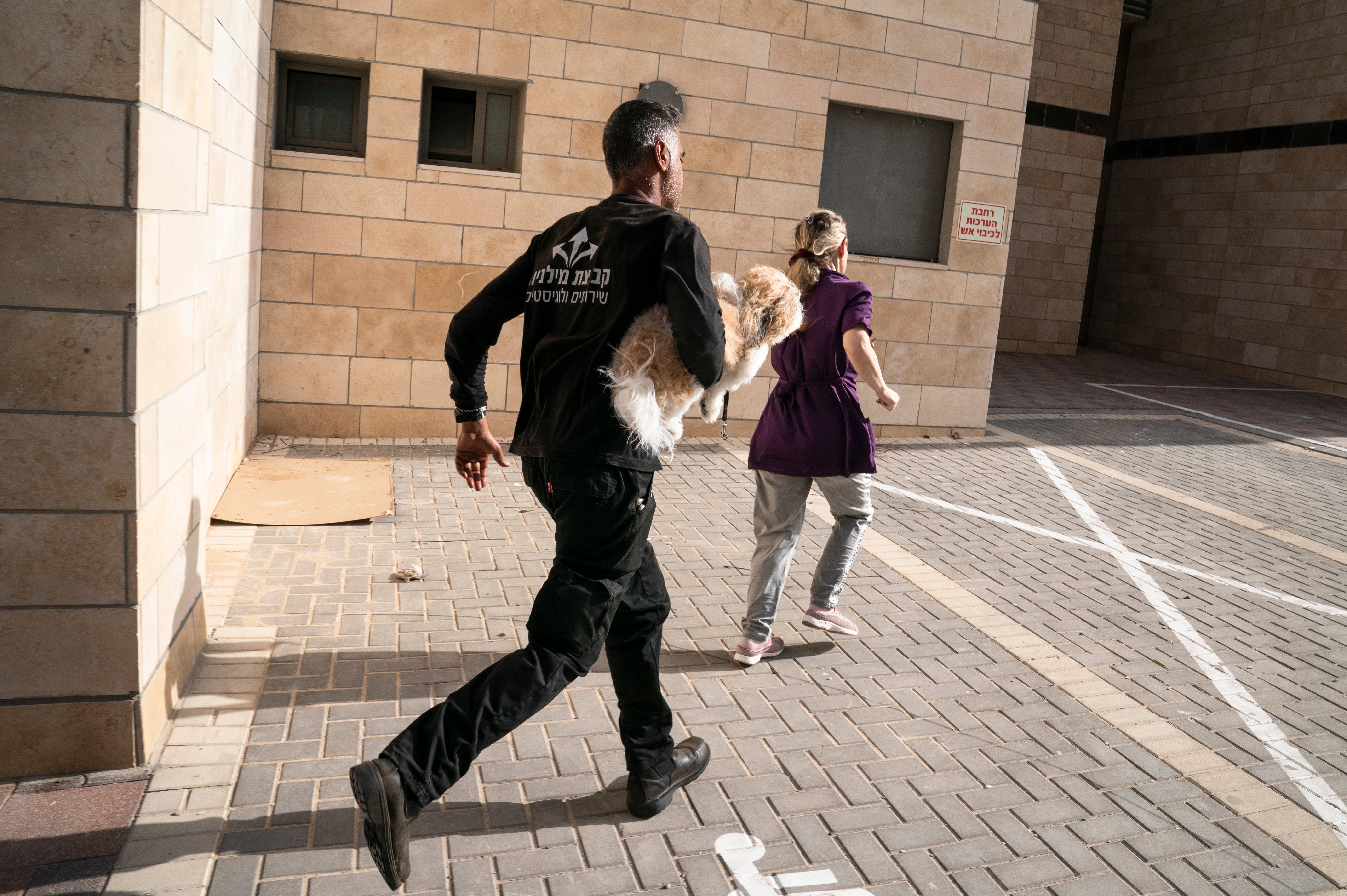 Pedestrians run to a bomb shelter as sirens blare to warn of incoming missiles fire from the Gaza Strip