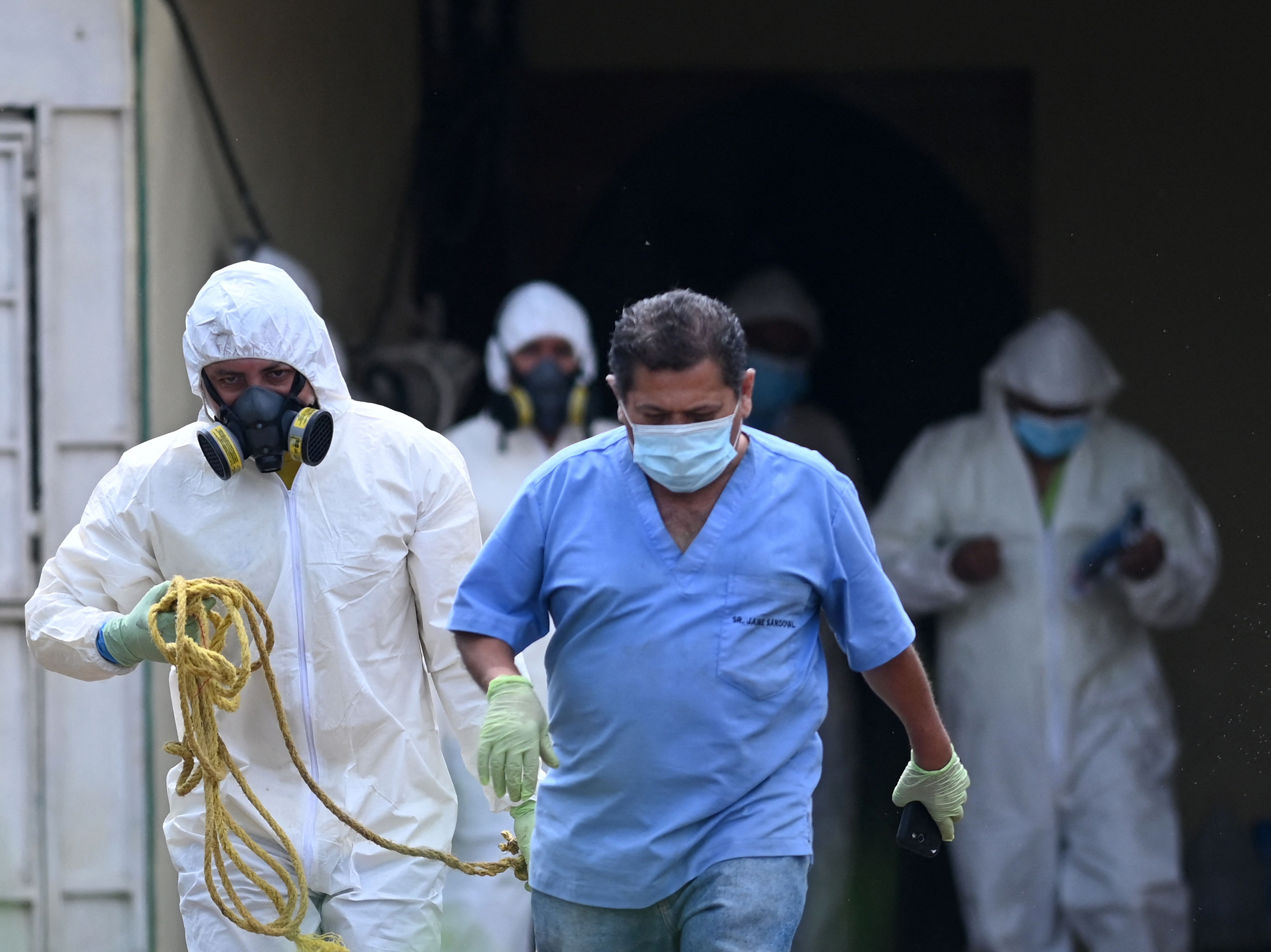 Forensic workers examine mass grave found in backyard of former police officer in western El Salvador.