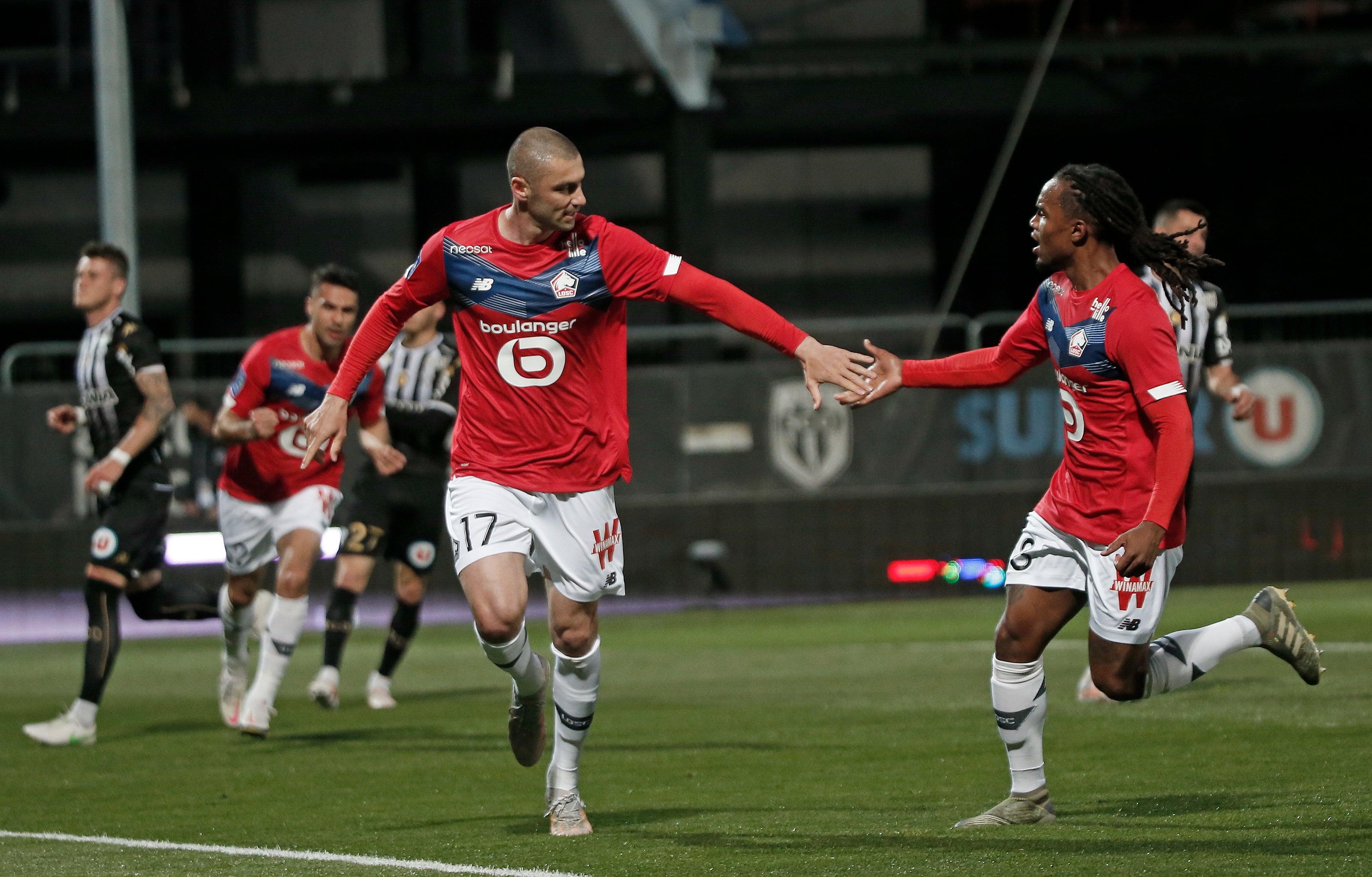 Burak Yilmaz celebrates with Renato Sanches after scoring a penalty which helped Lille clinch the Ligue 1 title