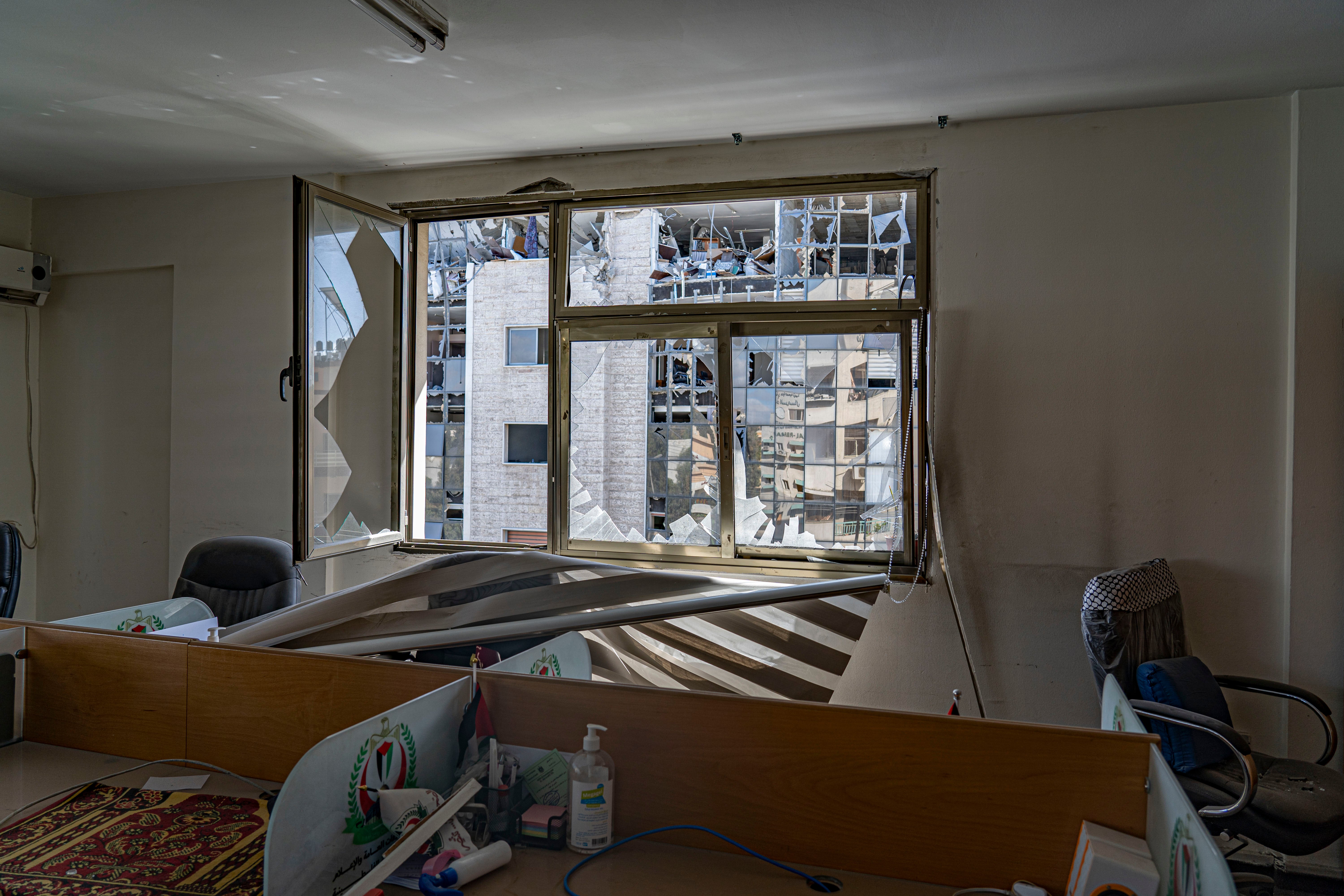 Destroyed offices of the health ministry building with the multi-storey building that was the target of the airstrikes in the background