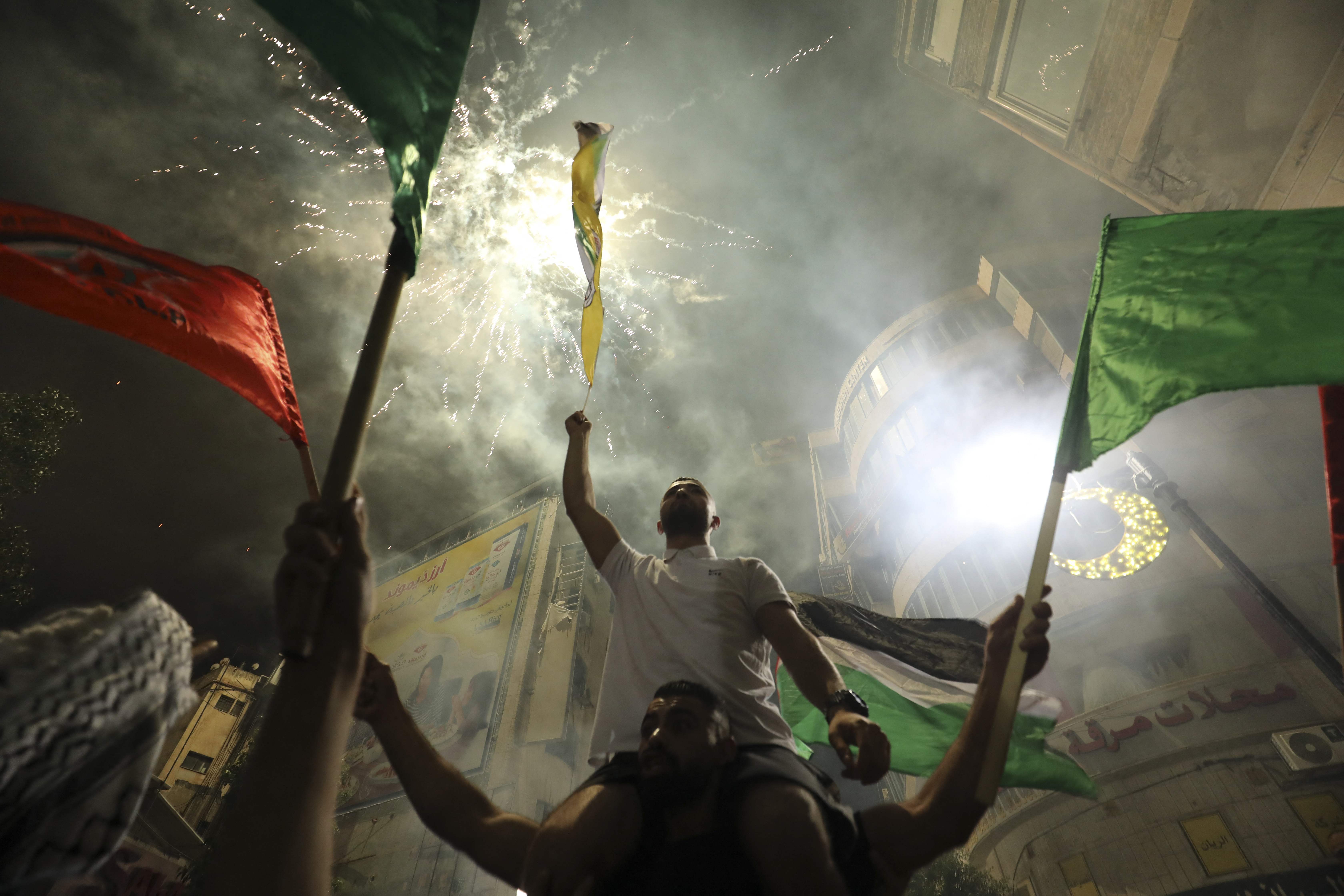 Palestinians celebrate in Ramallah in support of the resistance in Gaza, after the ceasefire was announced