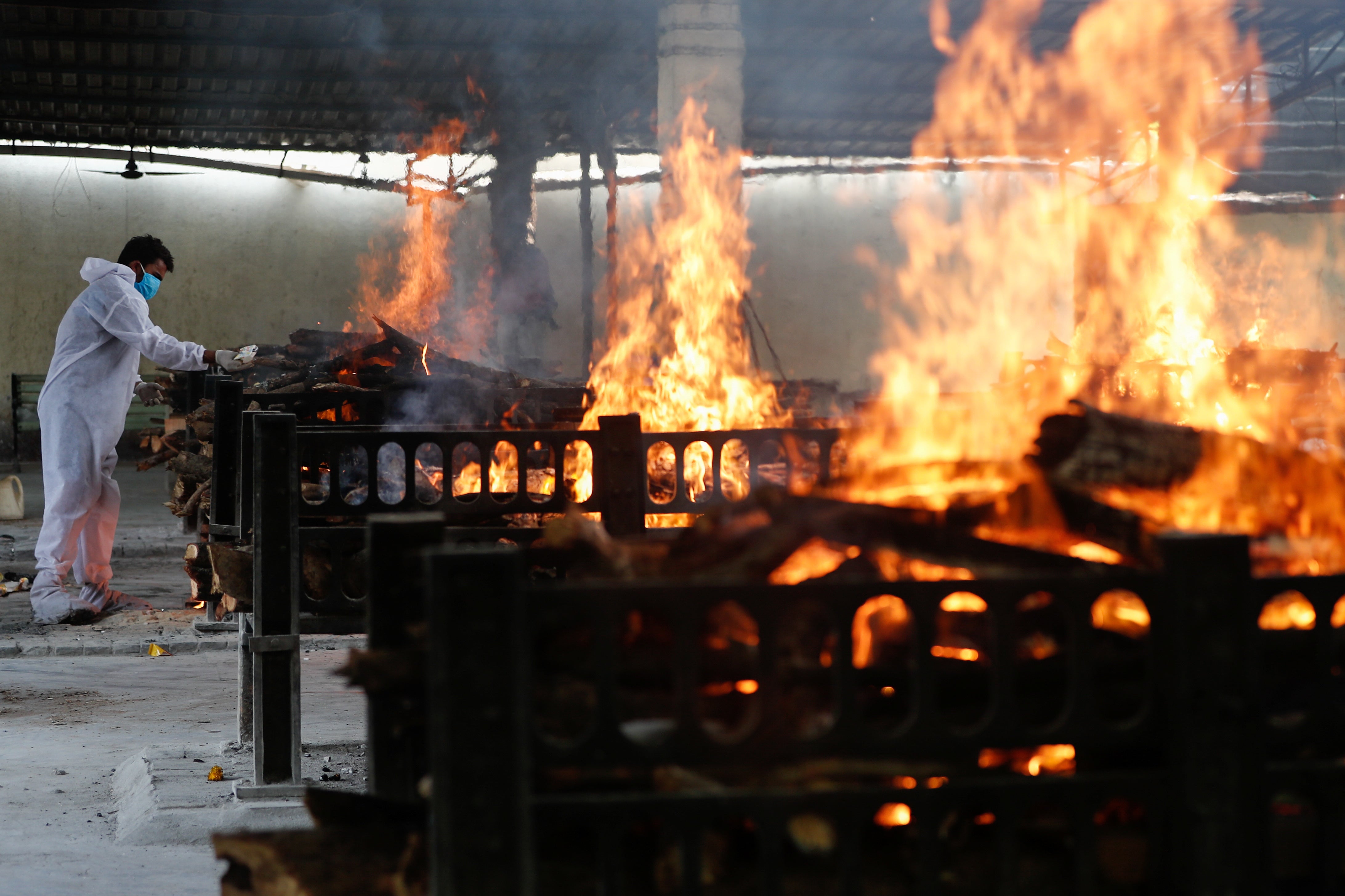 A frontline worker lights a funeral pyre at a hospital in Mumbai. The government is refusing external assistance. It is also denying public access to data on severity and patterns of the disease