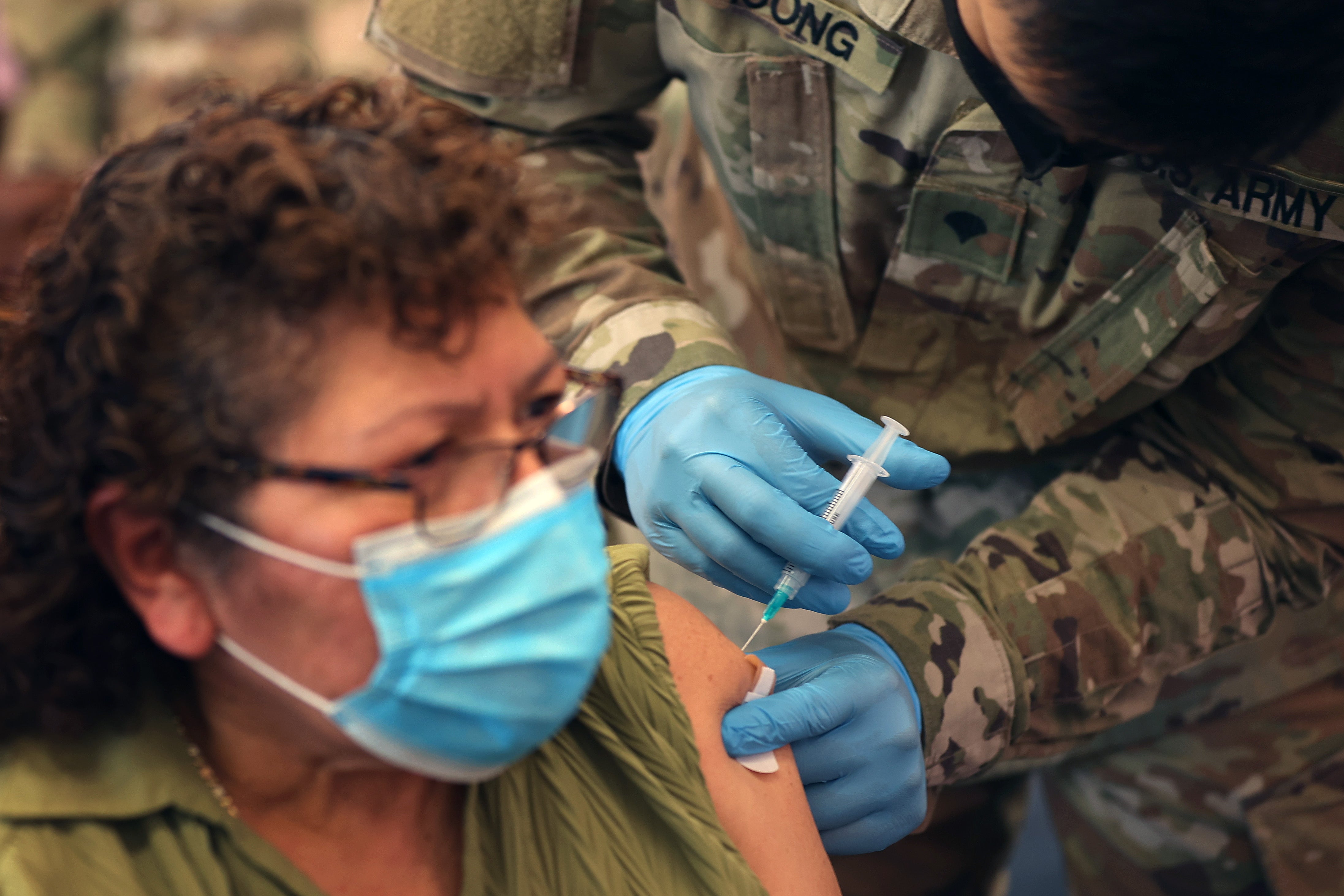 A Maryland National Guard Specialist administers a Covid vaccine