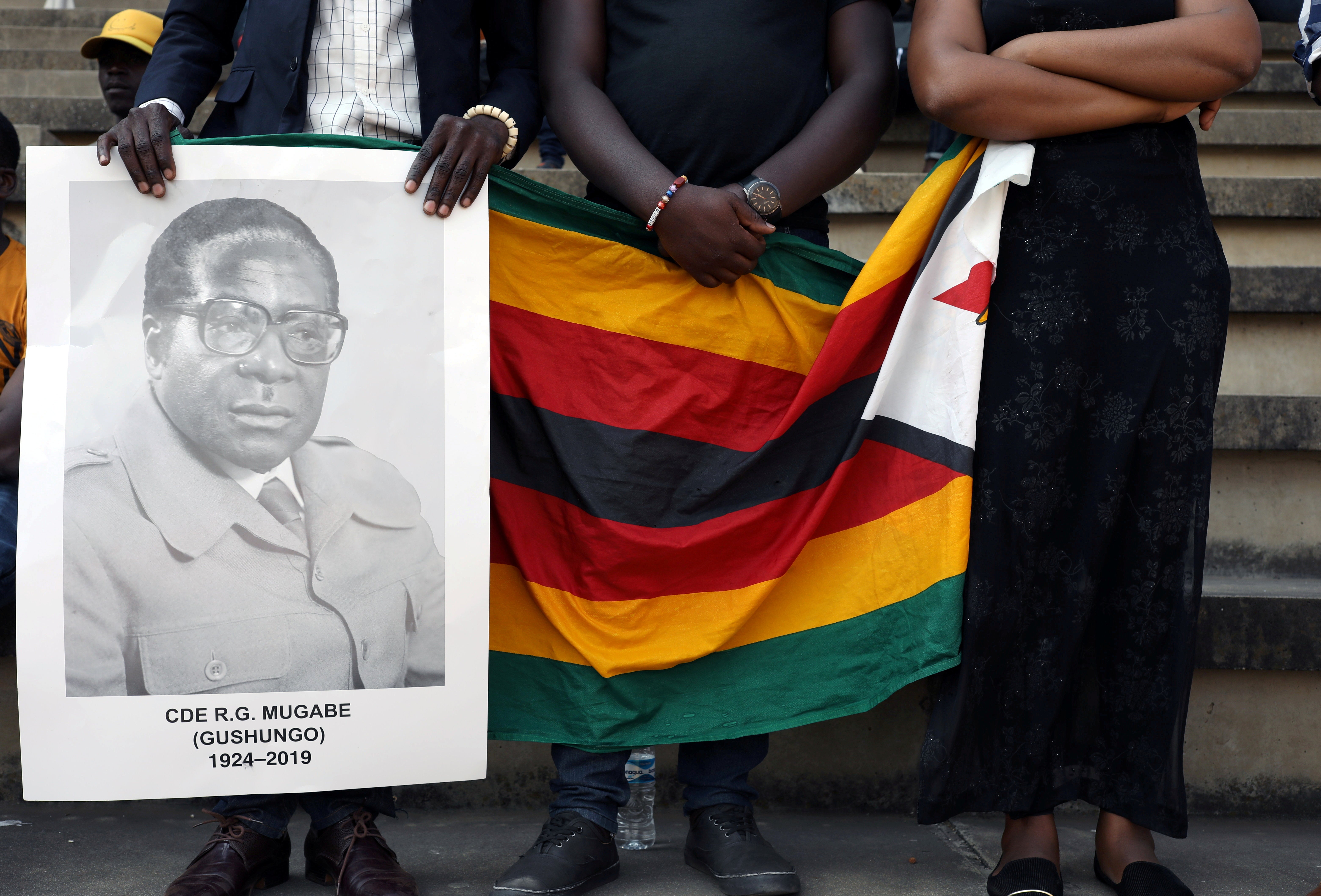 Mourners hold a poster during the state funeral of Zimbabwe's longtime ruler Robert Mugabe at a national sports stadium in Harare, Zimbabwe, 14 September 2019