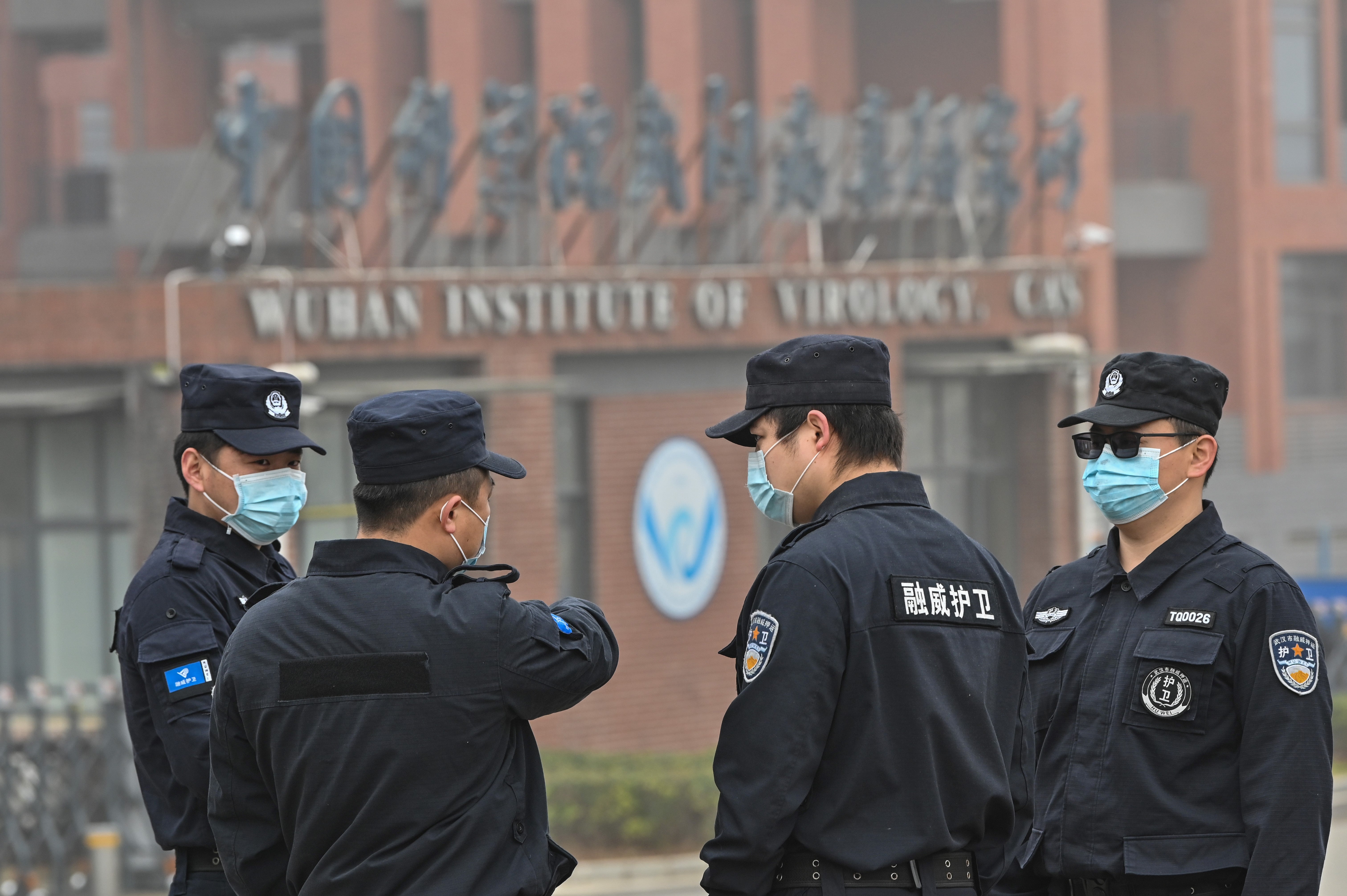 Security personnel stand guard outside the Wuhan Institute of Virology in Wuhan as members of the World Health Organization (WHO) team investigating the origins of the COVID-19 coronavirus make a visit