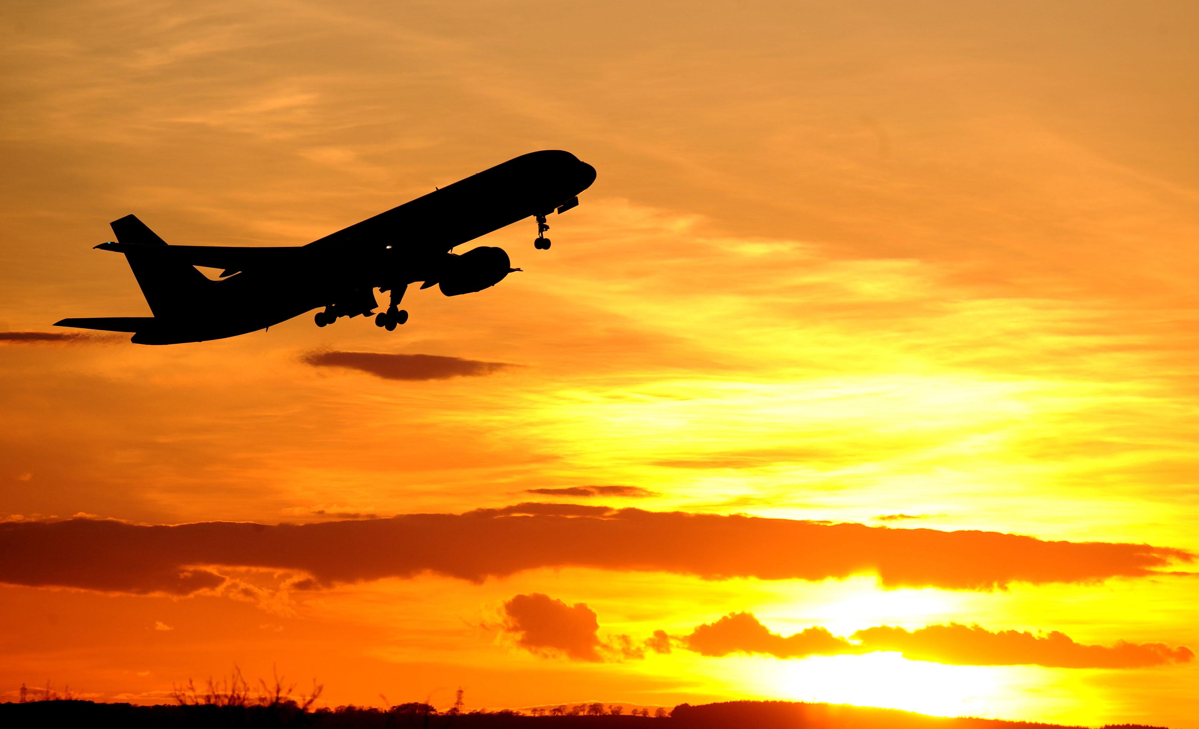 A plane takes off at sunset