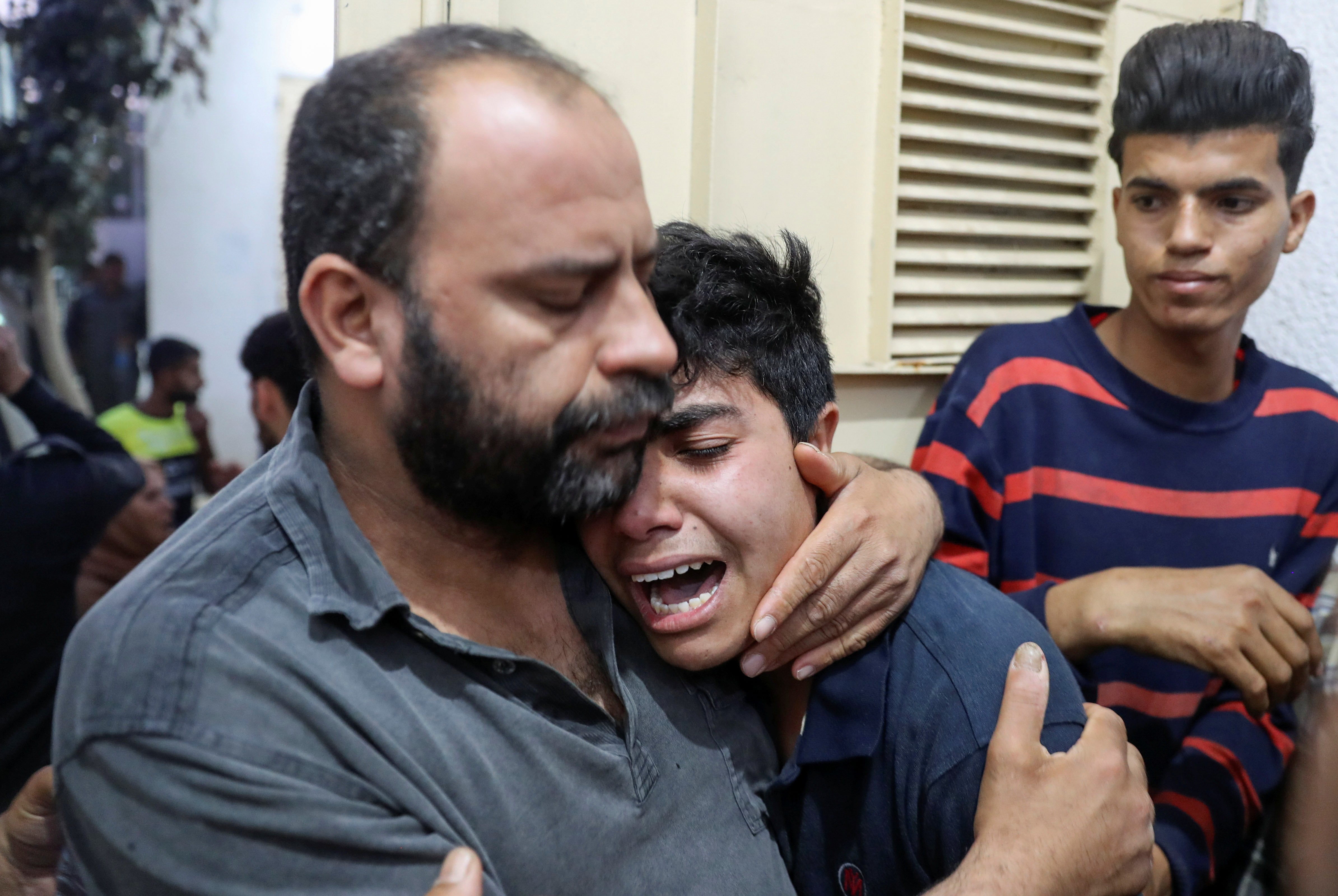 A relative of a Palestinian, who was killed amid a flare-up of Israeli-Palestinian violence, is comforted as he reacts at a hospital in the northern Gaza Strip May 10