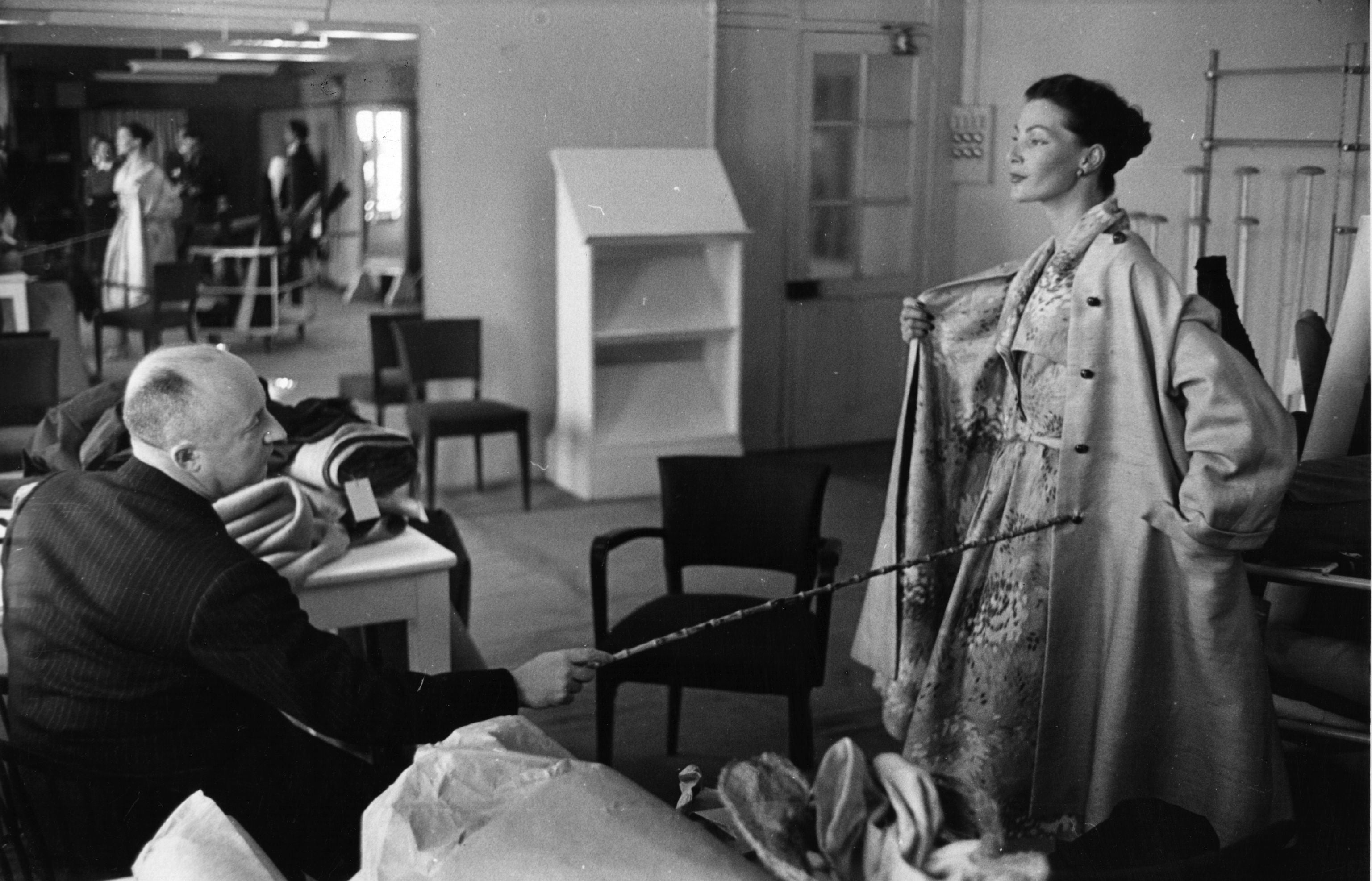 The French couturier Christian Dior inspects one of his designs in his Paris workroom