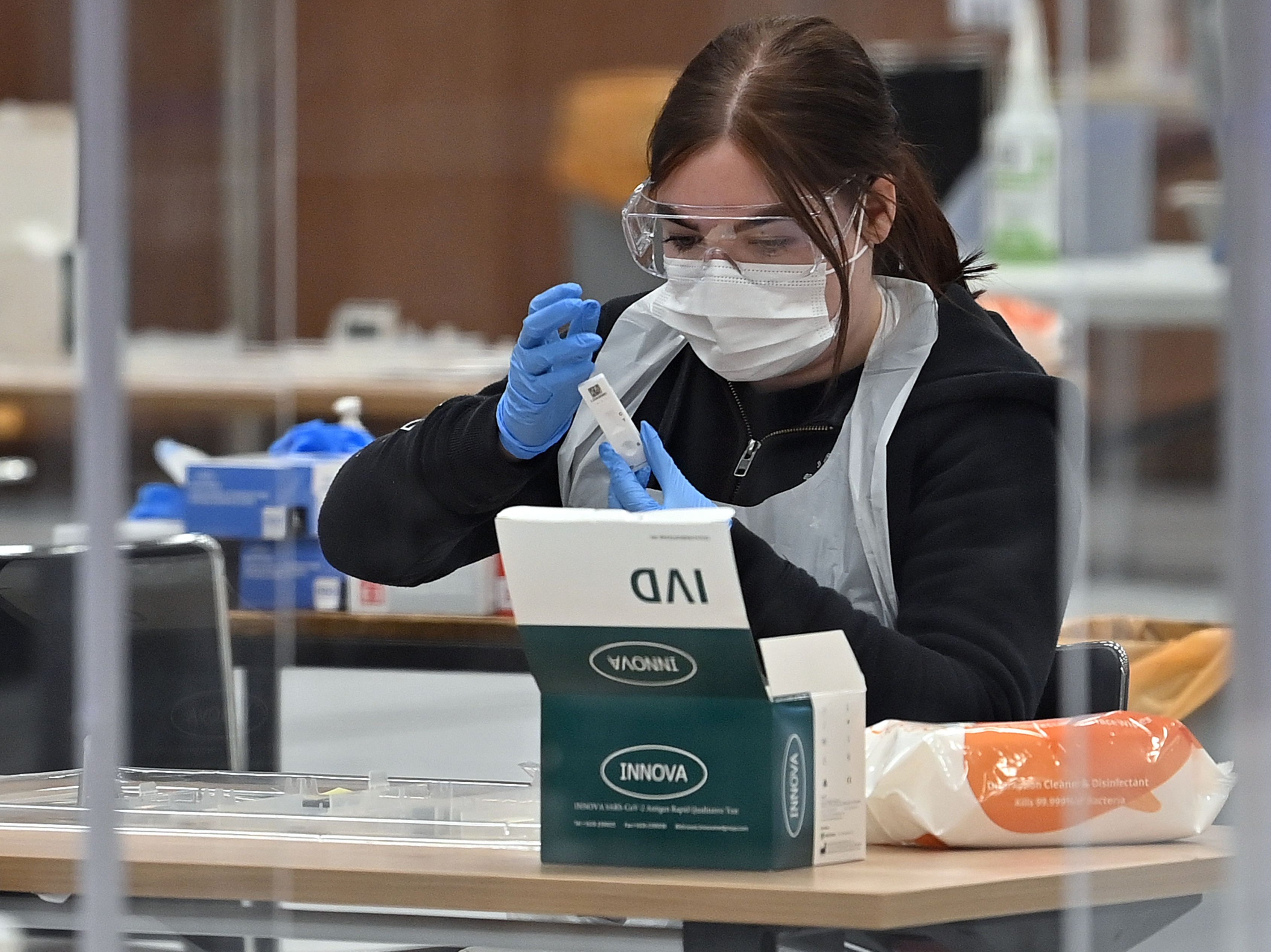 A worker processes an Innova lateral flow test taken by a Hull University student in April