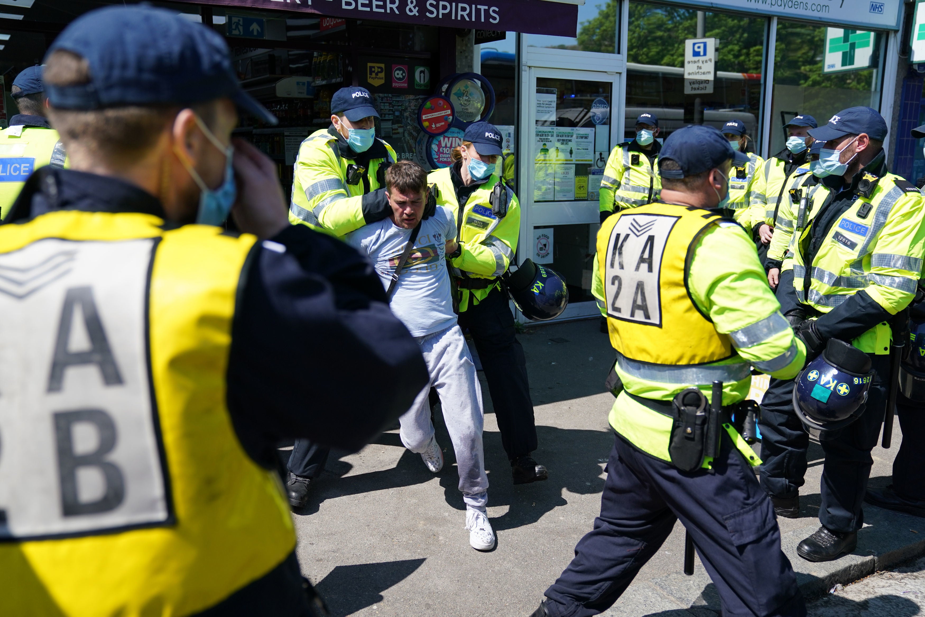 A man is detained by police during the march