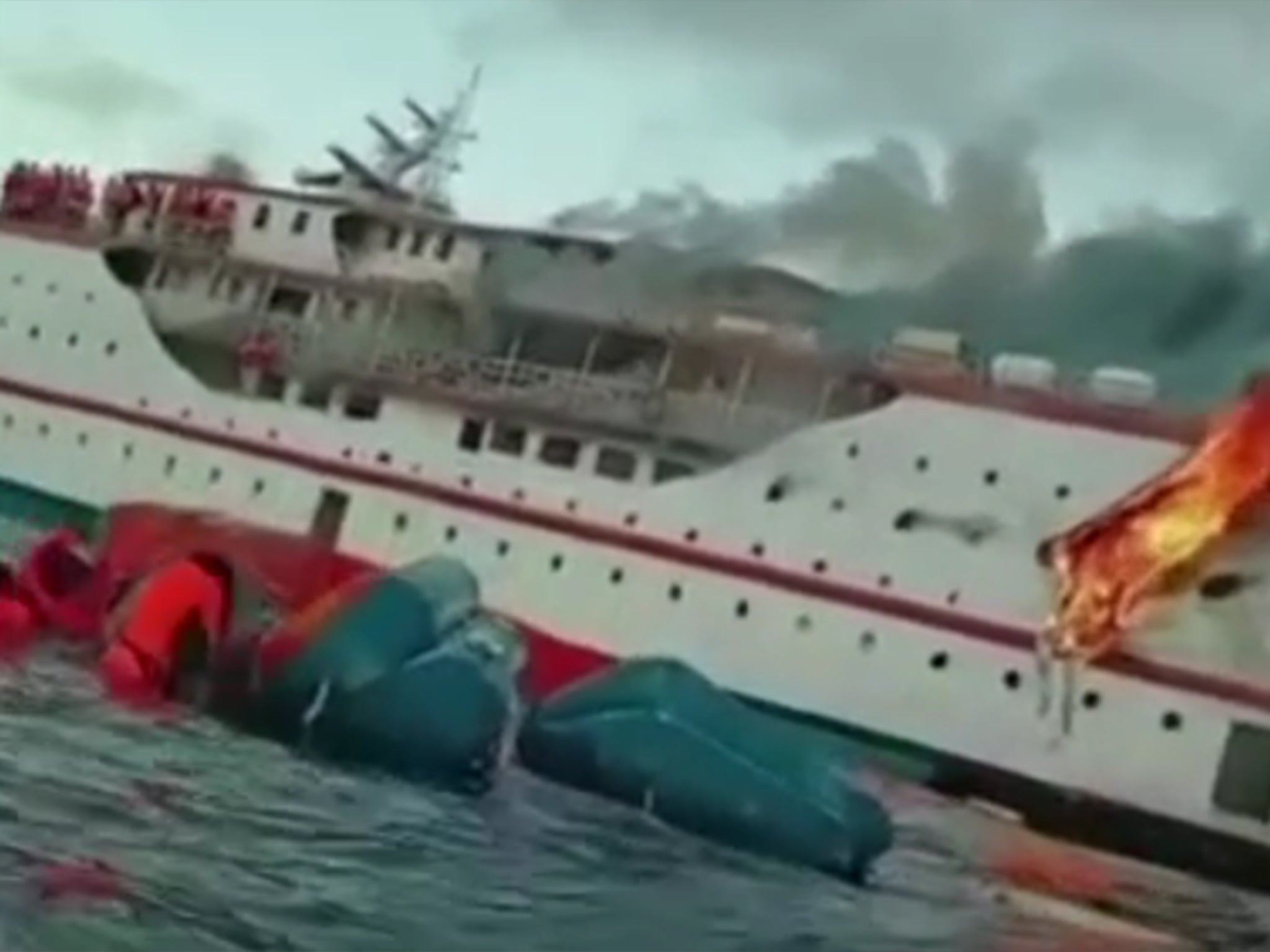 Screengrab from footage shows passengers clambering on board lifeboat as fire rages