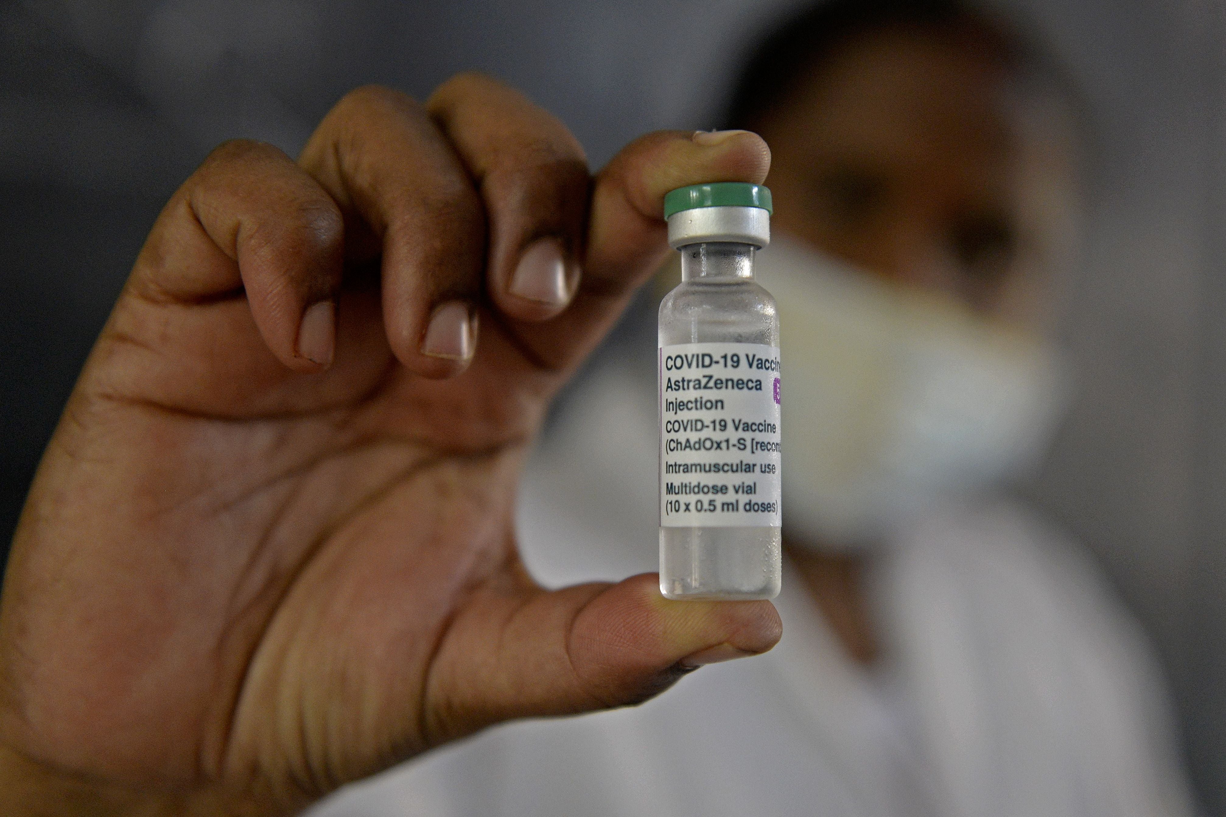 A health worker holds a vial of Covishield vaccine at a government school in Hyderabad on 29 May, 2021.